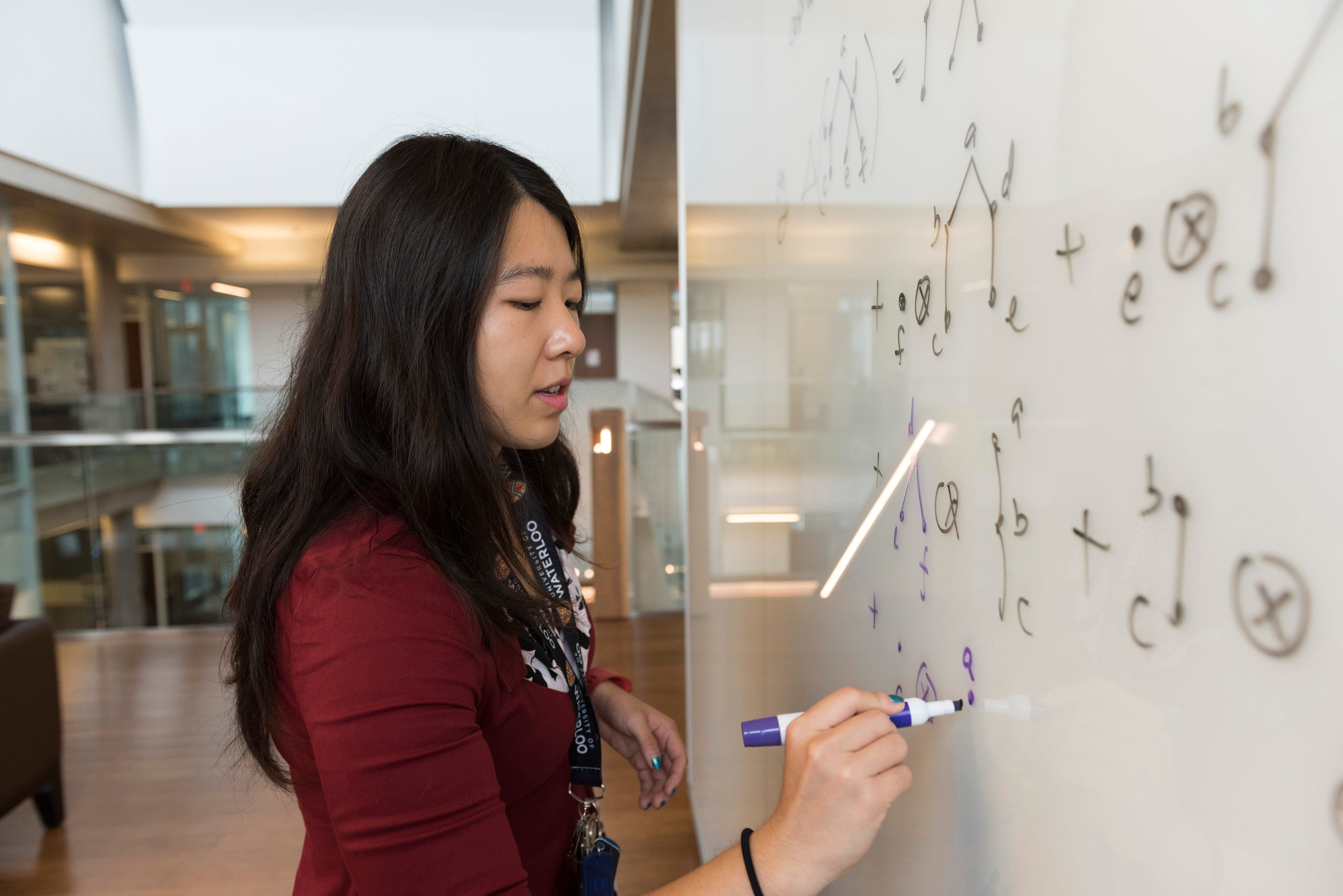 University of Waterloo student working on an equation on a whiteboard