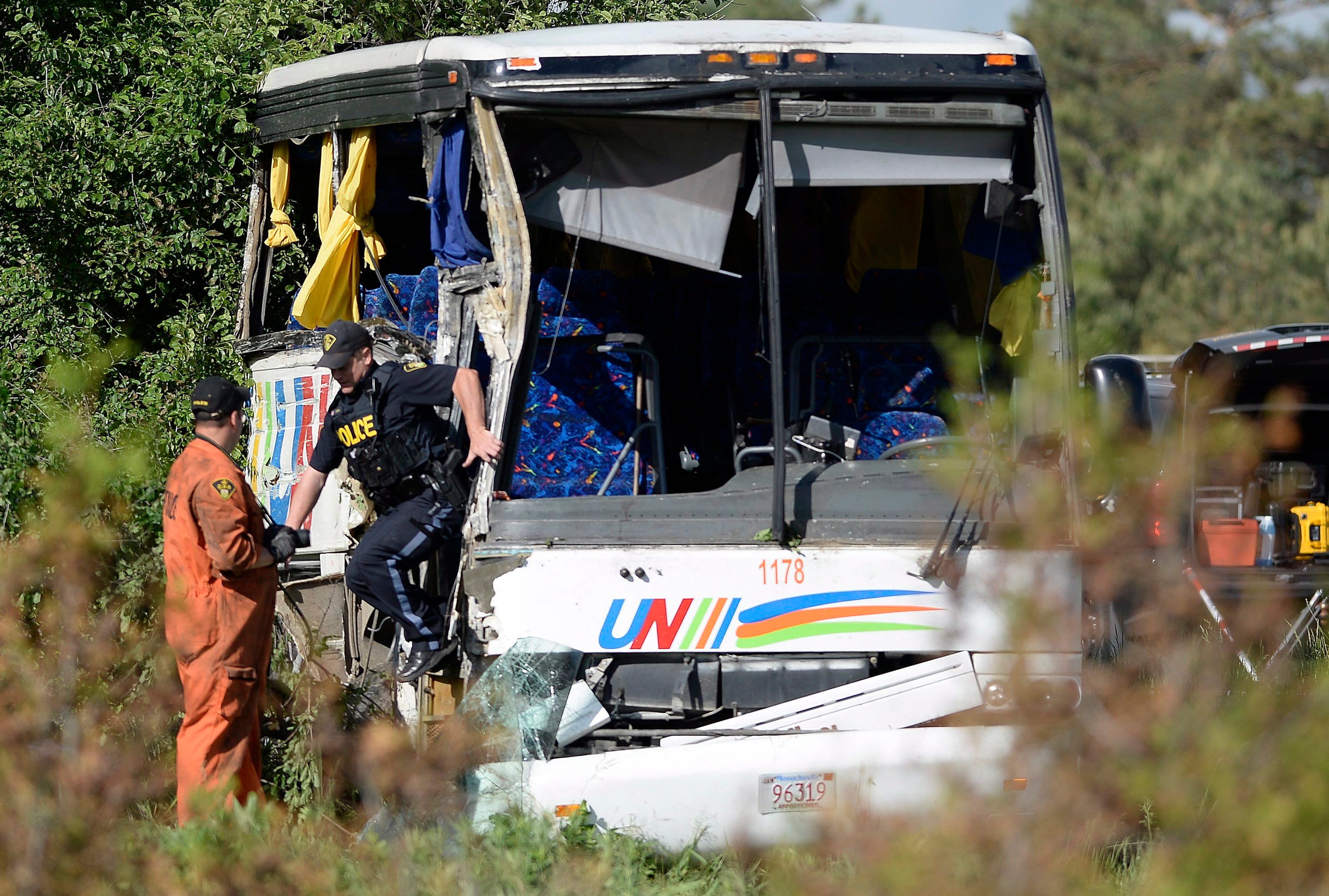 OPP officers work at the site of a crash involving a tour bus on Highway 401 West, near Prescott, Ont. on Monday, June 4, 2018. At least 24 people are in hospital, four with life-threatening injuries, after a bus crash in eastern Ontario, provincial police said Monday. THE CANADIAN PRESS/Justin Tang