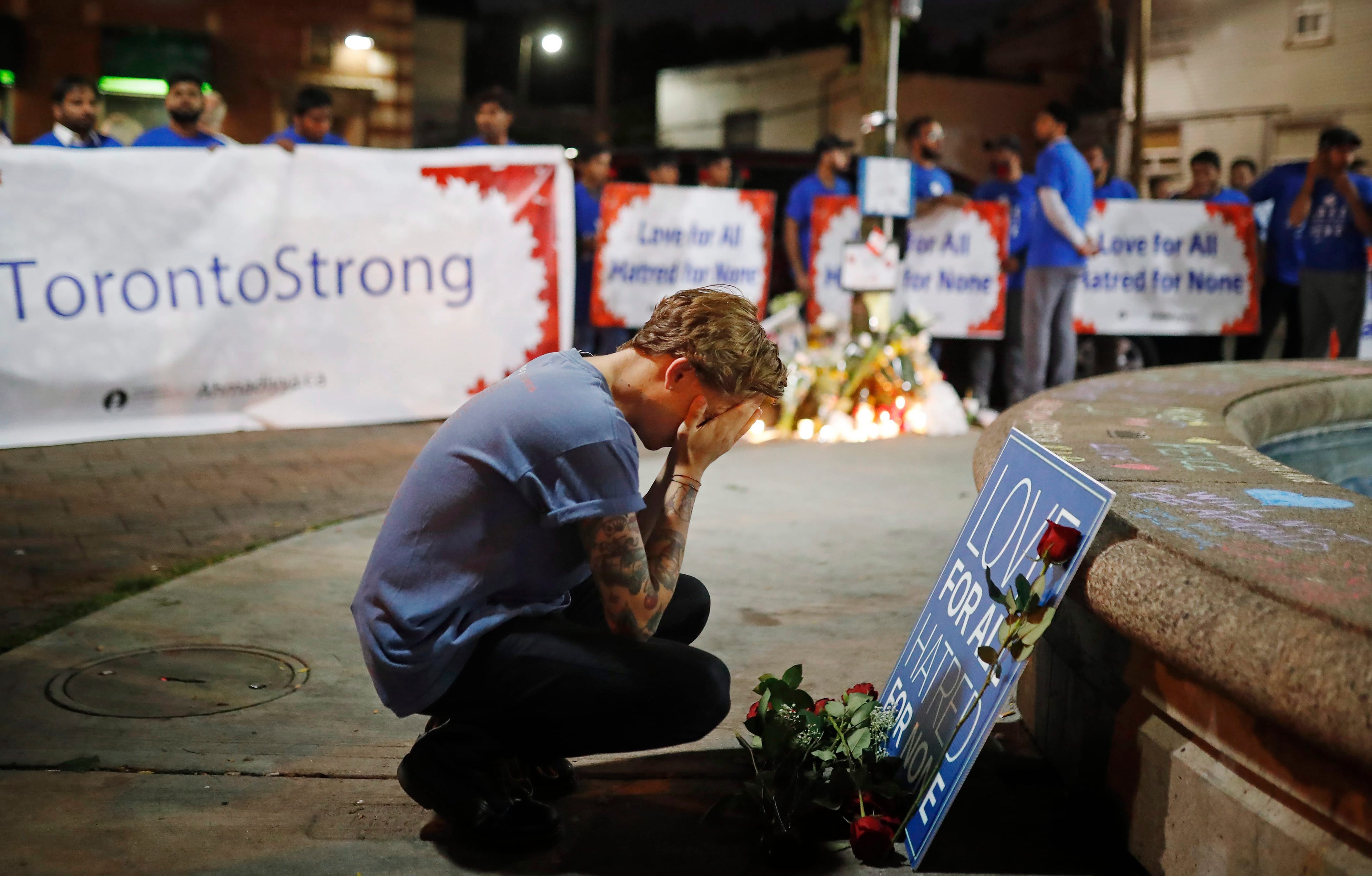 A young man reacts at a vigil remembering the victims of a shooting on Sunday evening on Danforth, Ave. in Toronto on Monday, July 23, 2018. THE CANADIAN PRESS/Mark Blinch