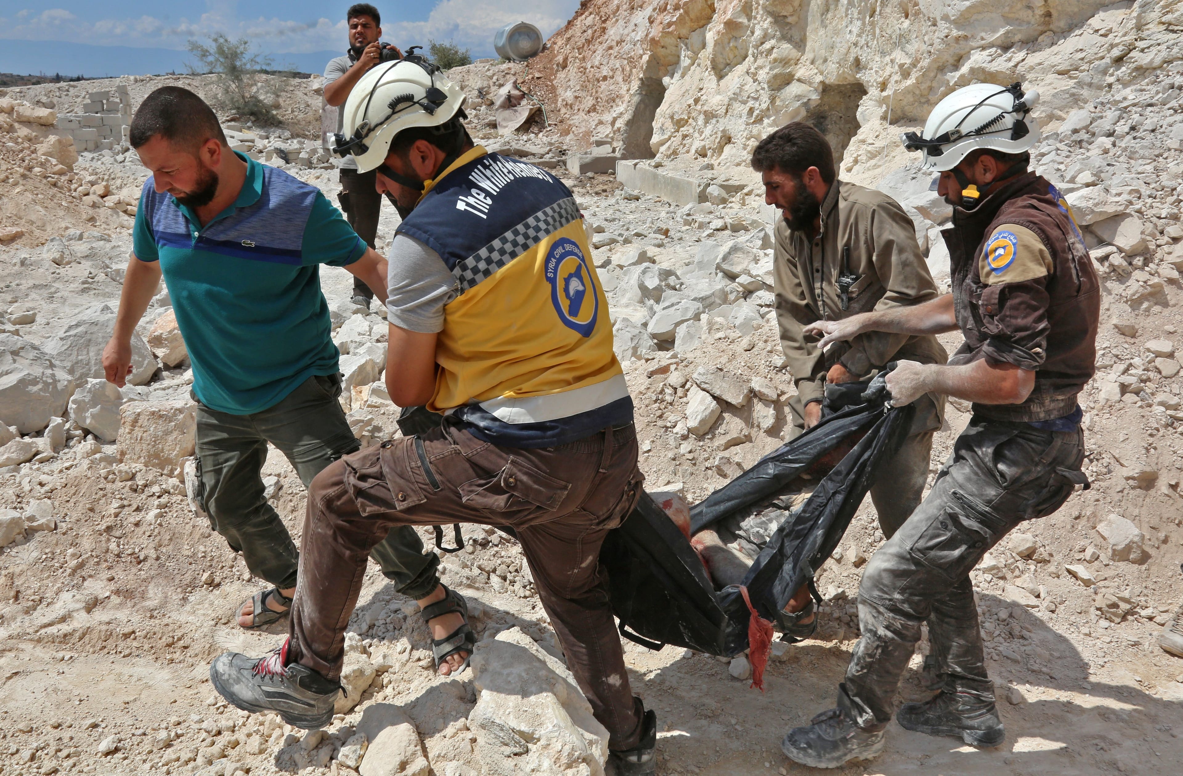 Members of the Syrian Civil Defence, also known as the "White Helmets", carry a victim after airstrikes in the southern part of Idlib province. (ANAS AL-DYAB/AFP/Getty Images)