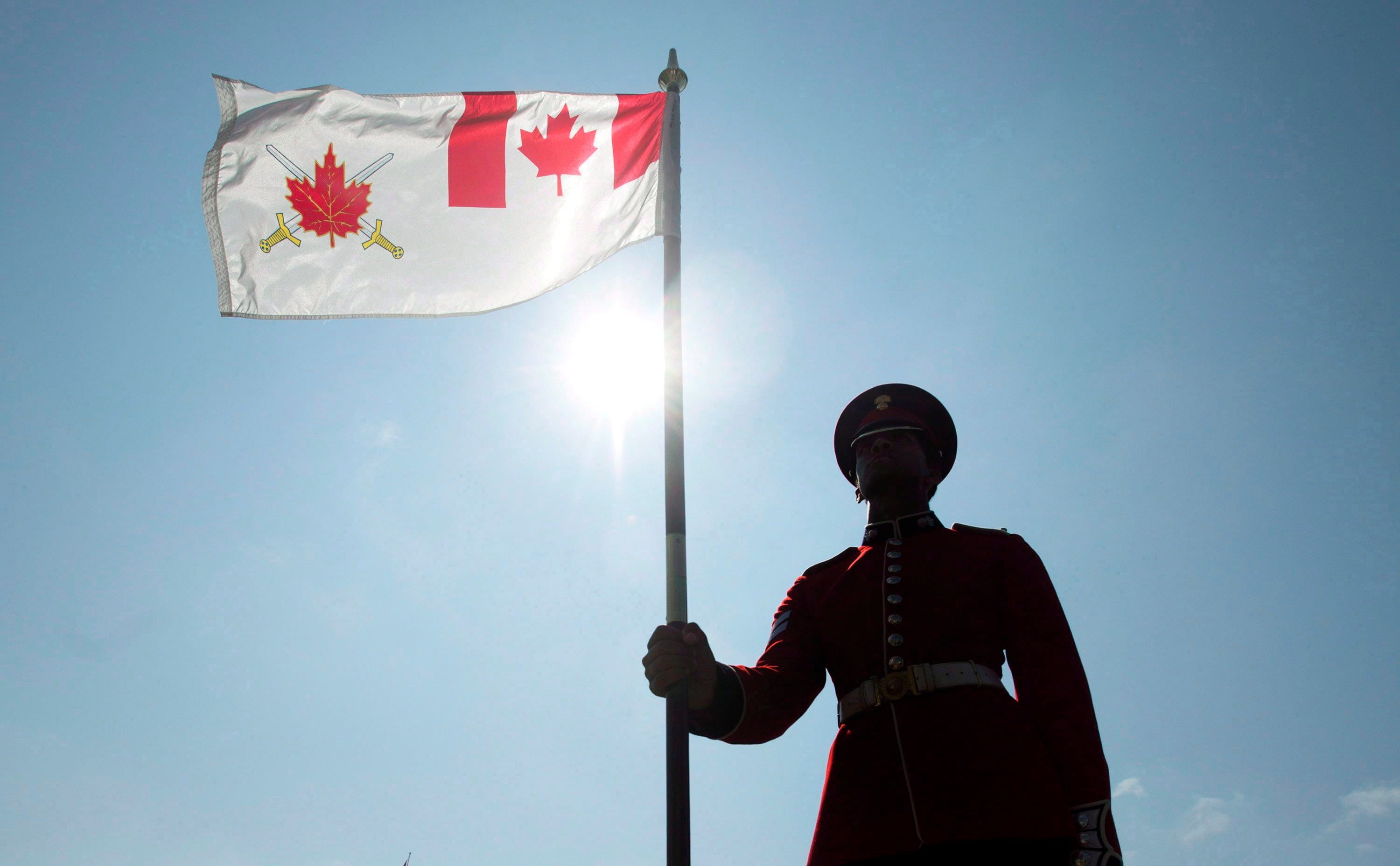A ceremonial guardsman holds the Canadian Land Forces Command flag during a change of command parade on Parliament Hill, in Ottawa on Thursday, July 18, 2013. (Adrian Wyld/CP)