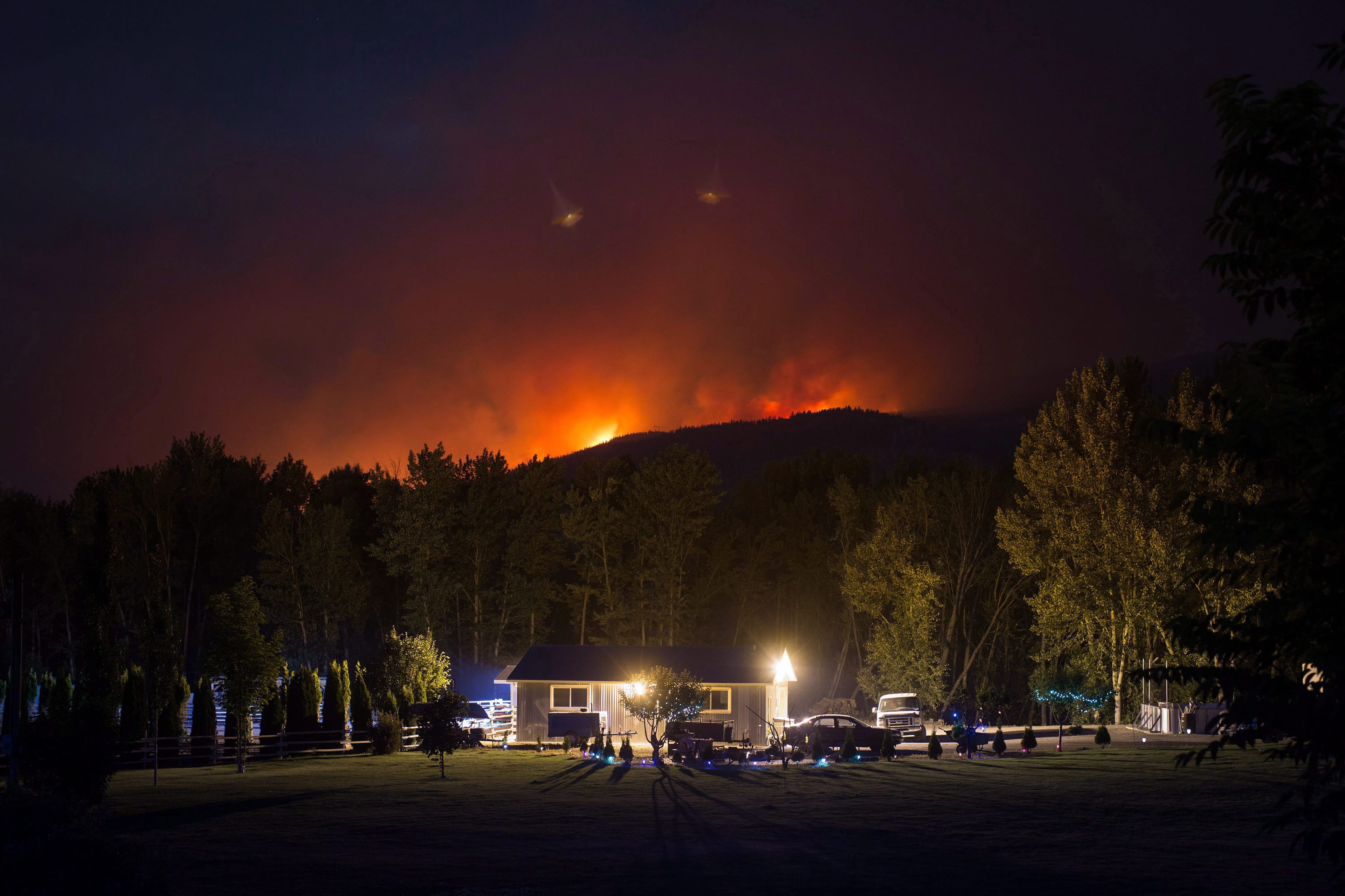 A home in Cache Creek, B.C., cowers below raging wildfires in July 2017 (Darryl Dyck/CP)