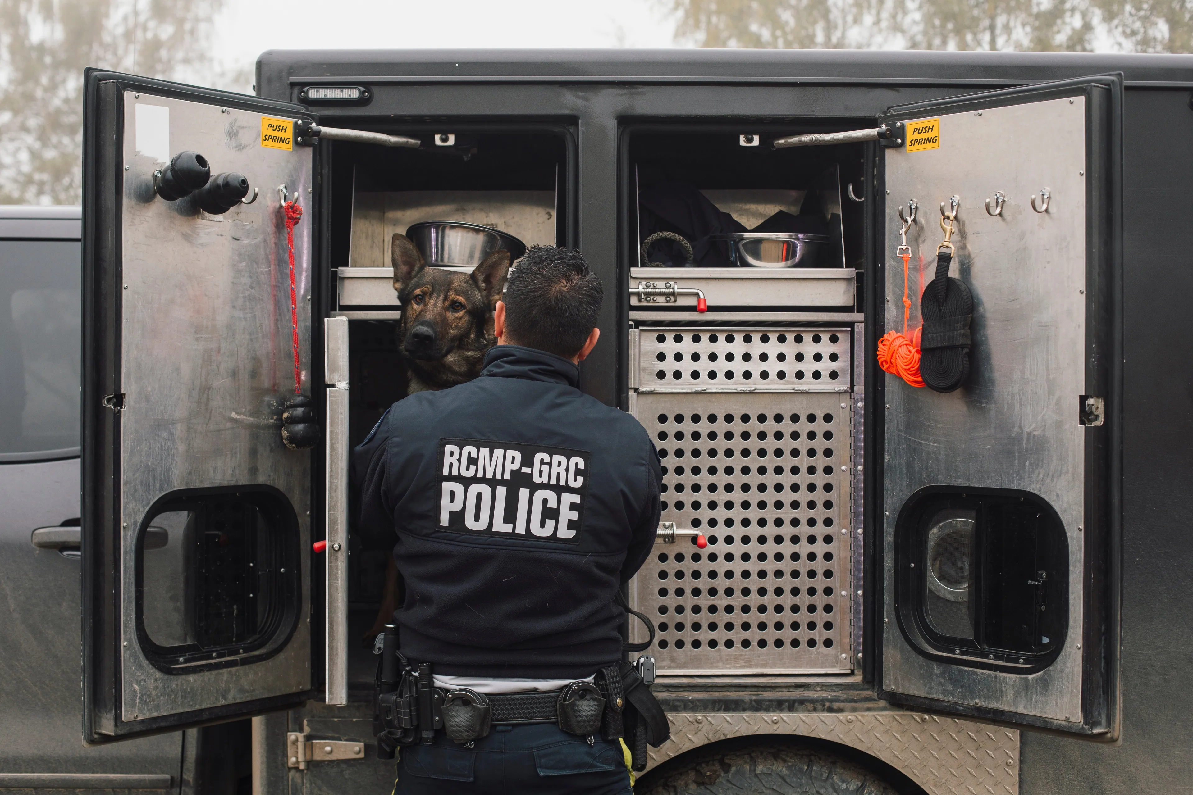 Cst. Dave Ling puts his dog Janga back in his kennel at the RCMP Police Dog Service Training Centre in Innisfail, Alberta. (Photograph by Amber Bracken)