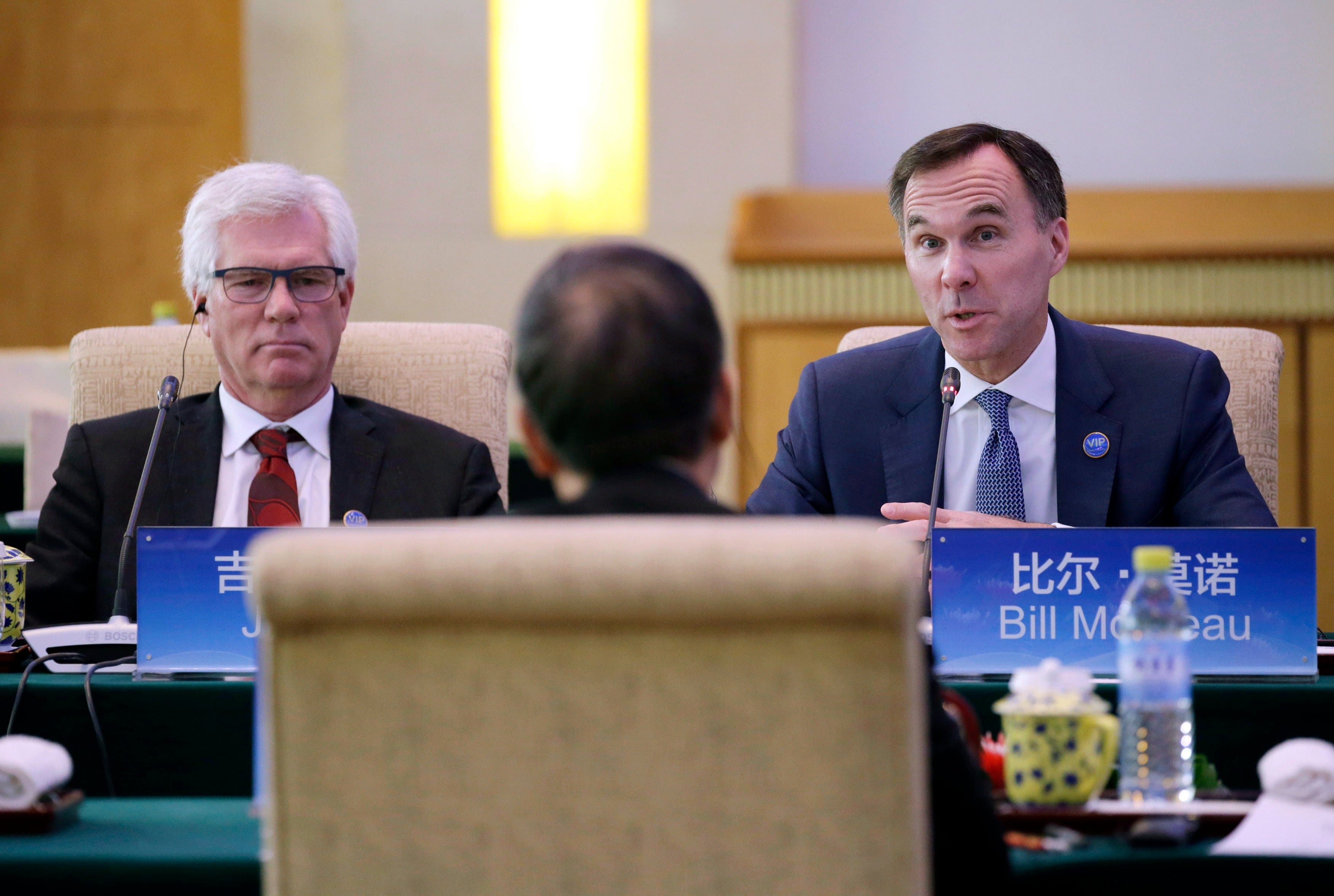 Canadian Finance Minister Bill Morneau, right, speaks next to International Trade Diversification Minister Jim Carr at the first China-Canada economic and financial strategy dialogue in Beijing, China, Monday, Nov. 12, 2018. (Jason Lee/Pool Photo via AP)