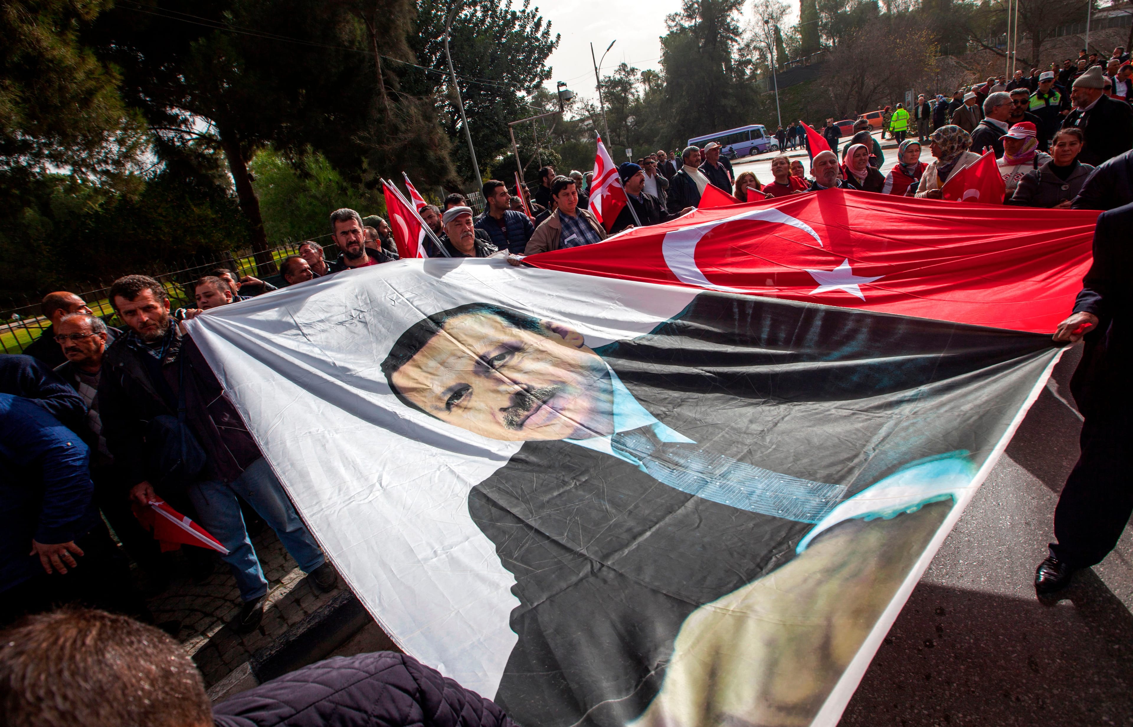 Protesters spread a large banner depicting Turkish President Recep Tayyip Erdogan alongside another of a Turkish flag on Jan. 22, 2018. (Birol Bebek/AFP/Getty Images)