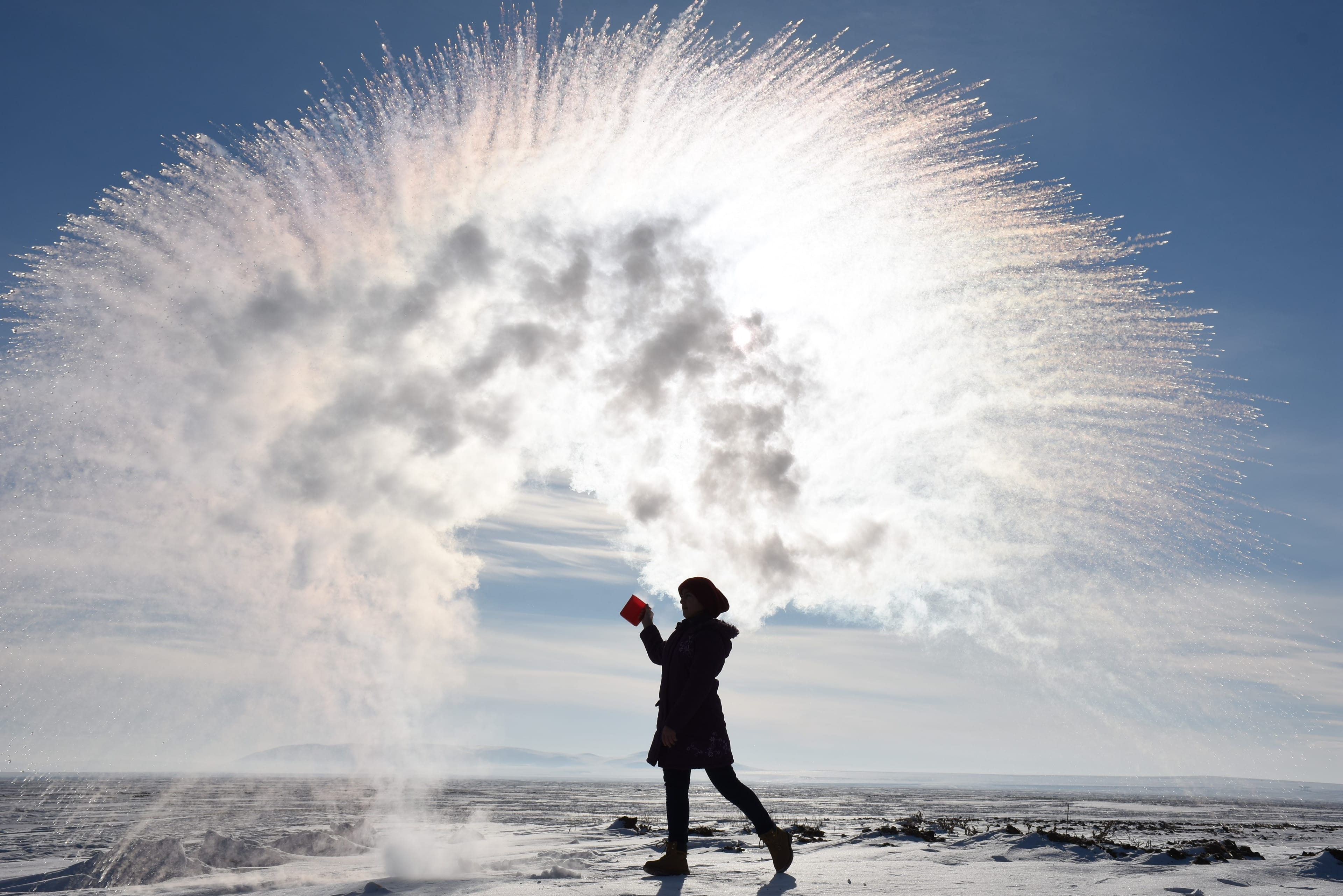 A woman tosses hot water into the freezing cold air, at a temperature of minus 20 degrees Celcius in Kars, Turkey on Jan. 20, 2019. (Photo by Ismail Kaplan/Anadolu Agency/Getty Images)