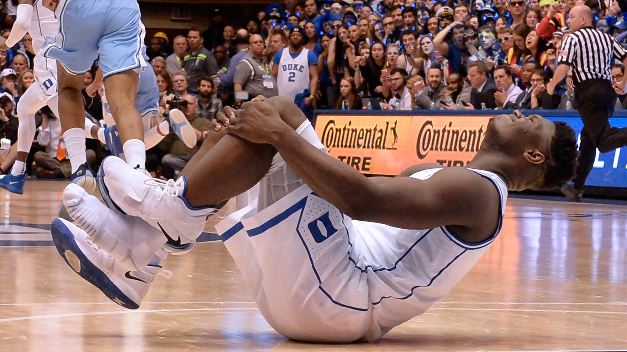 Zion Williamson of Duke University holds his knee in agony after his shoe blew out during the opening moments of a game against North Carolina (Chuck Liddy/Raleigh News/Getty Images)