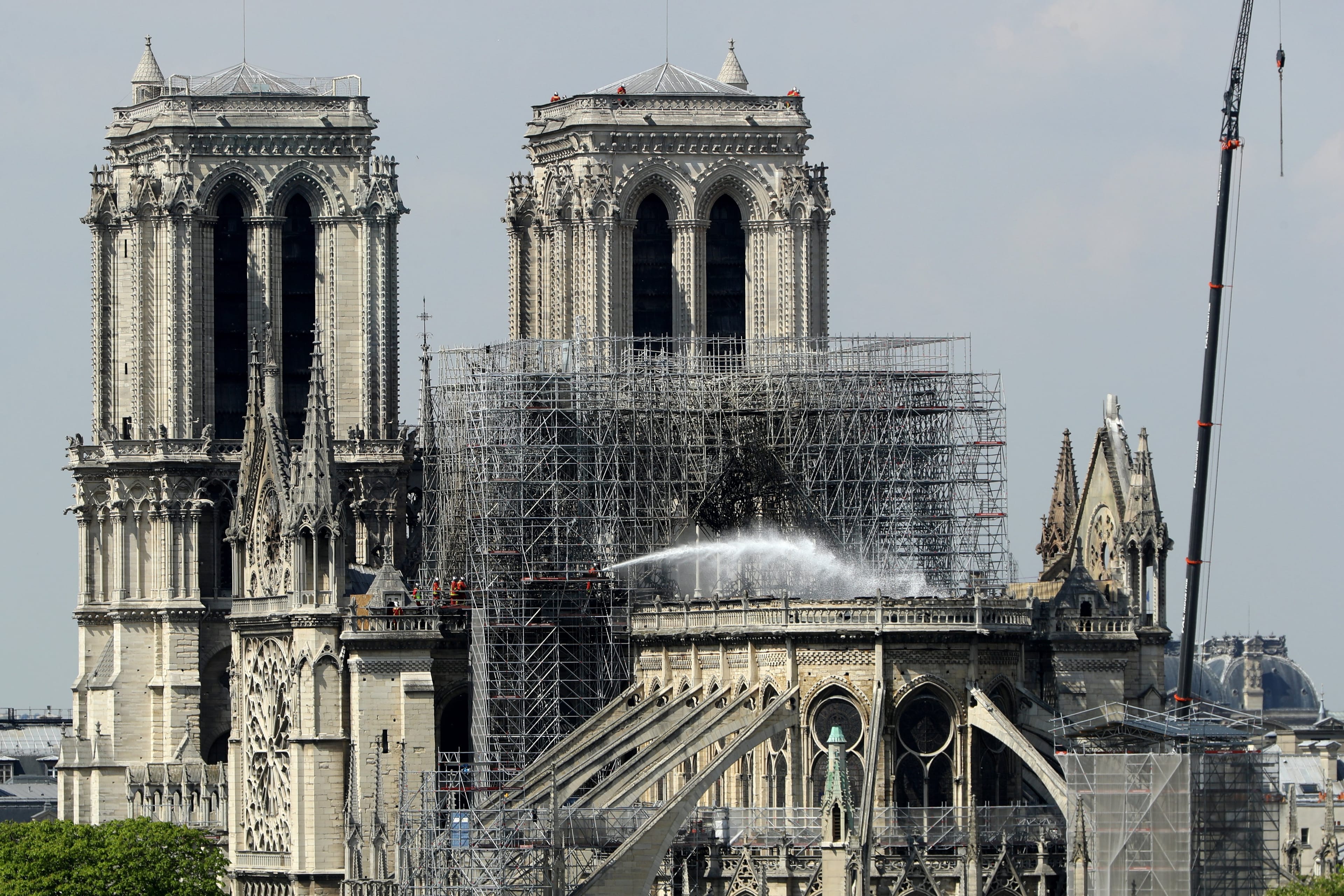 A firefighter hoses down a section of Notre Dame Cathedral following a major fire on Monday, April 17, 2019 in Paris, France (Dan Kitwood/Getty Images)