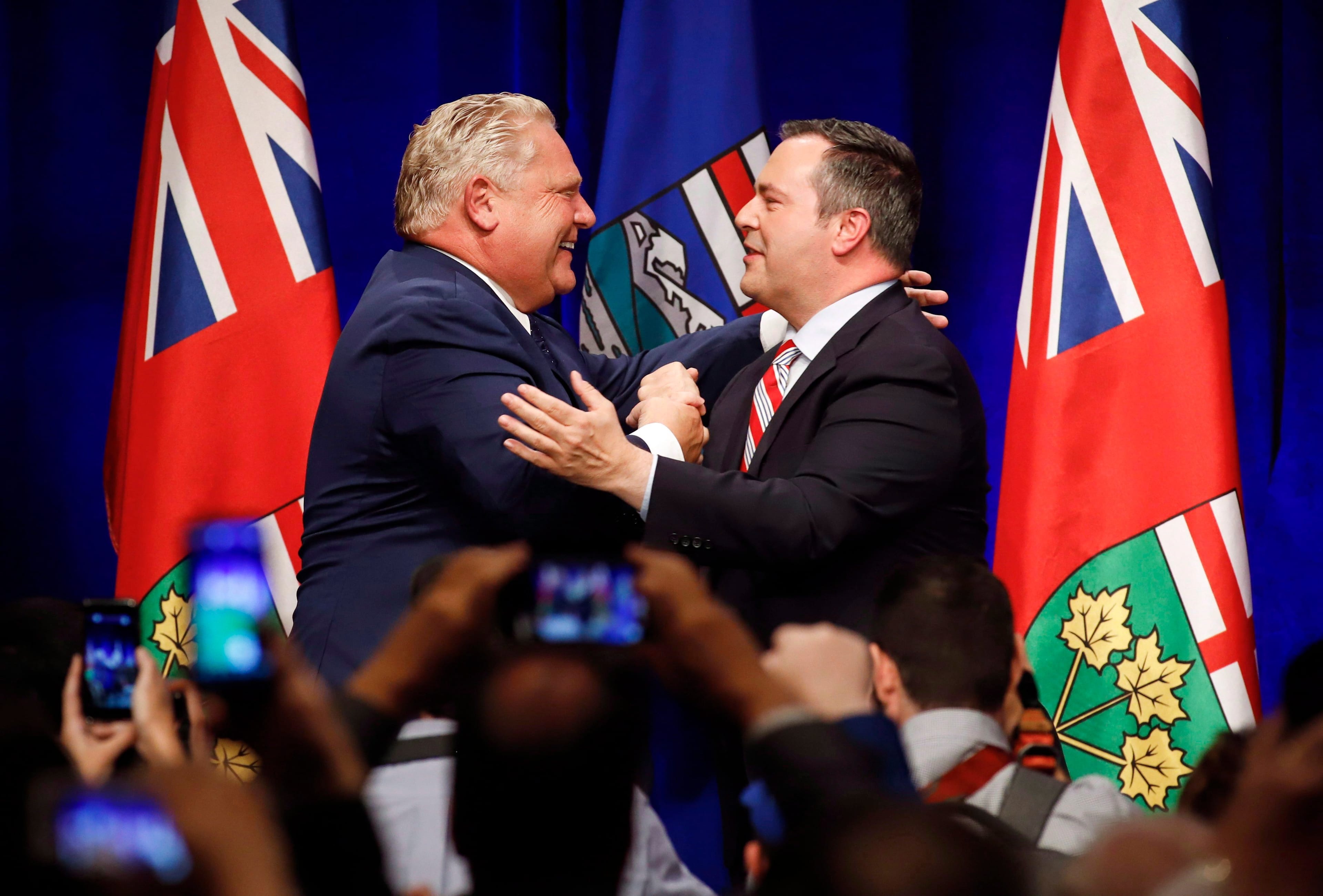 Ontario Premier Doug Ford, left, and United Conservative Leader Jason Kenney embrace on stage at an anti-carbon tax rally in Calgary, Friday, Oct. 5, 2018. (Jeff McIntosh/CP)
