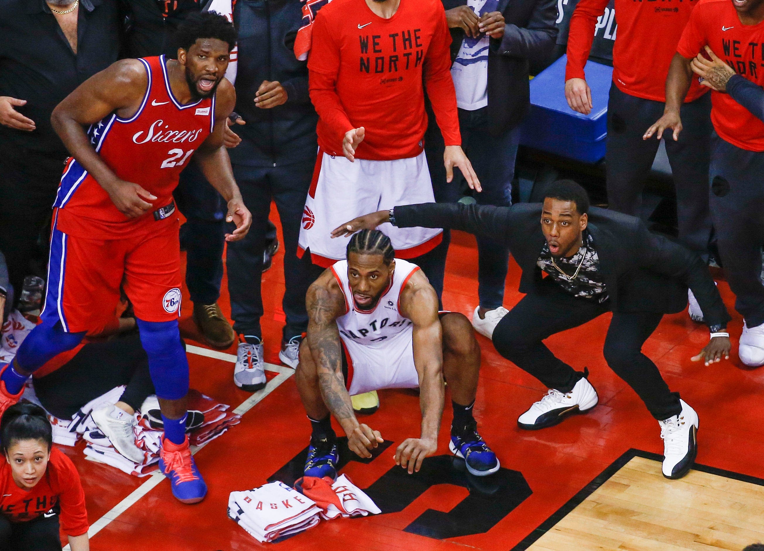 Leonard, centre, squats; Philadelphia's Joel Embiid watches from the corner; and Raptor's guard Jordan Lloyd, in street clothes, waits for the 'The Shot' to drop on Sunday at Scotiabank Arena (Rick Madonik/Toronto Star/Getty Images)