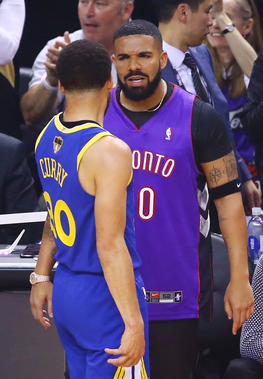 Drake (right) and Steph Curry exchange words during a timeout in the first quarter during Game One of the 2019 NBA Finals between the Golden State Warriors and the Toronto Raptors. (Vaughn Ridley/Getty Images)