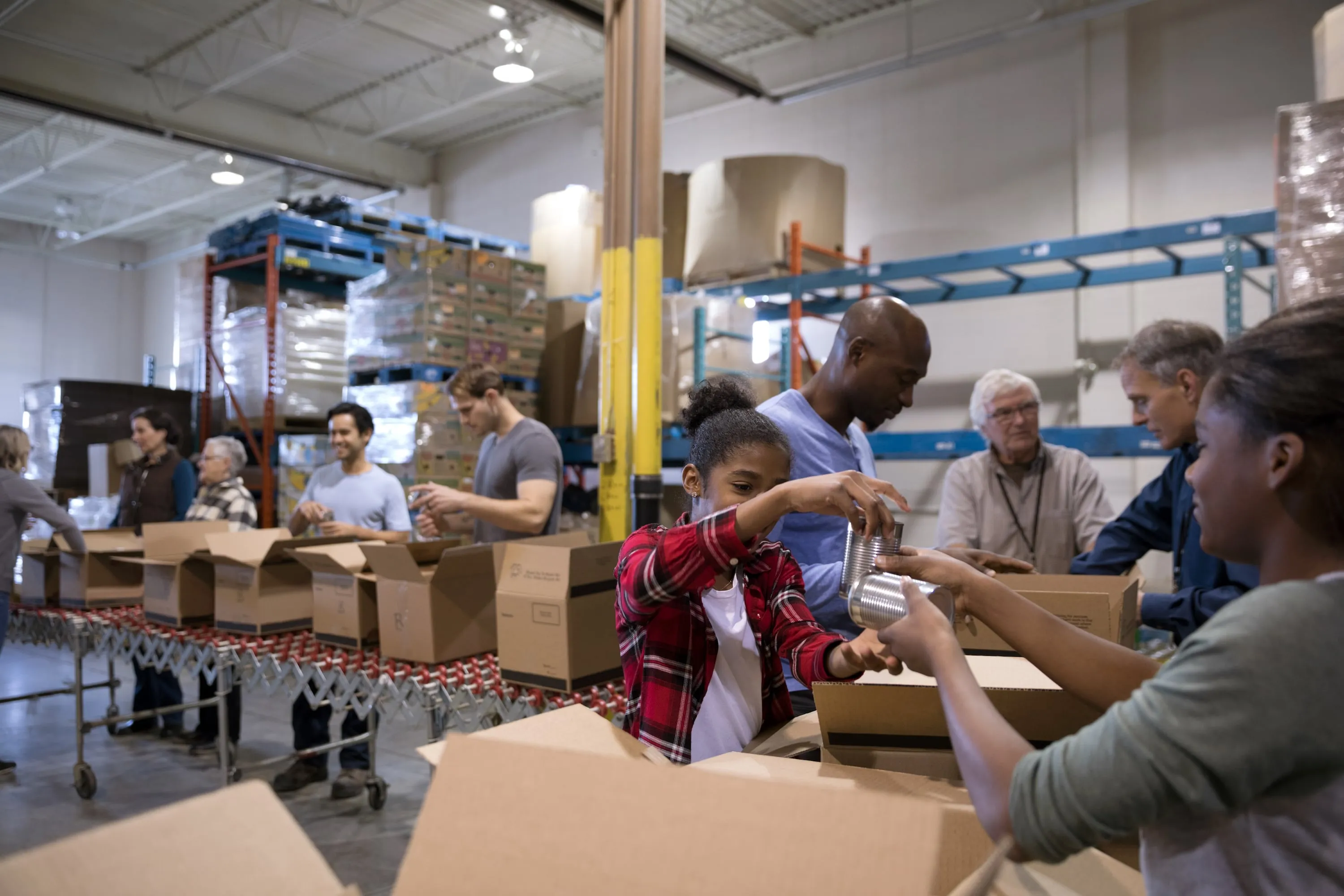 Volunteers filling boxes for a food bank (Hero Images/Getty Images)