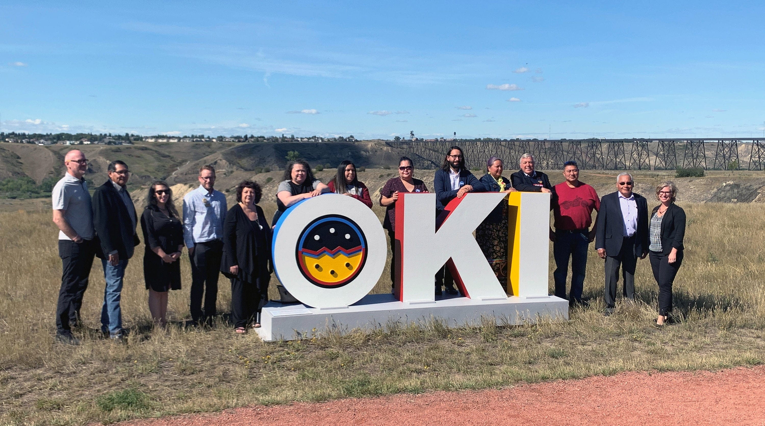 Mayor Spearman with members of the Reconciliation Lethbridge Advisory Committee on the newly unveiled Oki project. Amanda Scout is pictured in this photo, standing behind the K of Oki. (The City of Lethbridge)