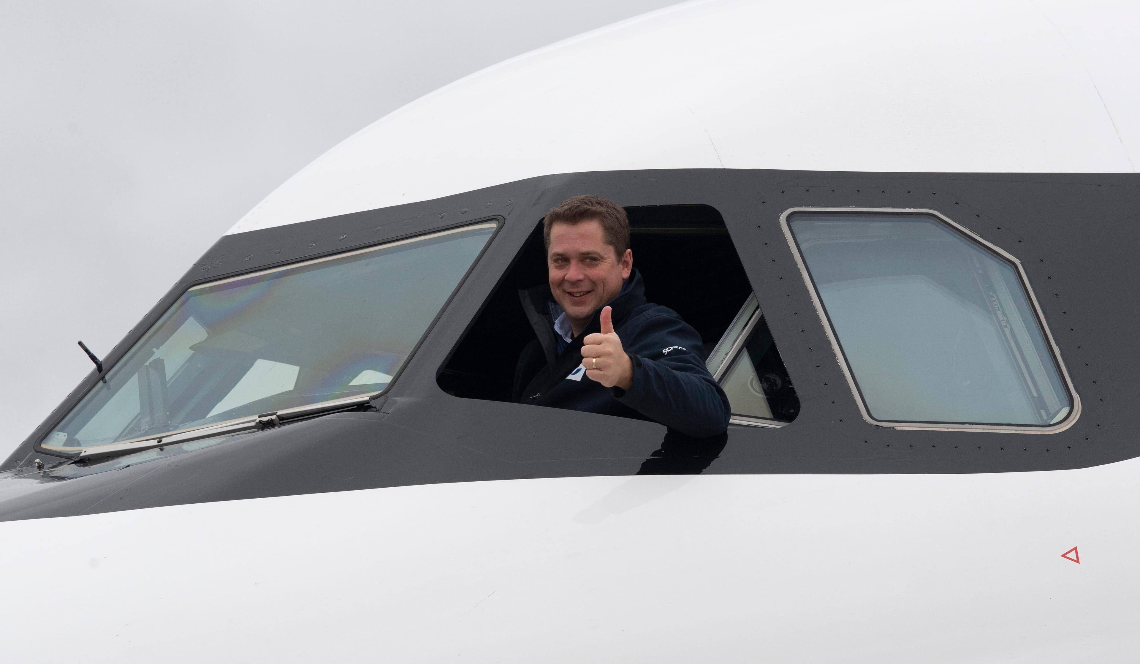 Conservative leader Andrew Scheer gives the thumbs up from the cockpit of his campaign plane in Fredericton, Oct. 18, 2019. (Adrian Wyld/CP)