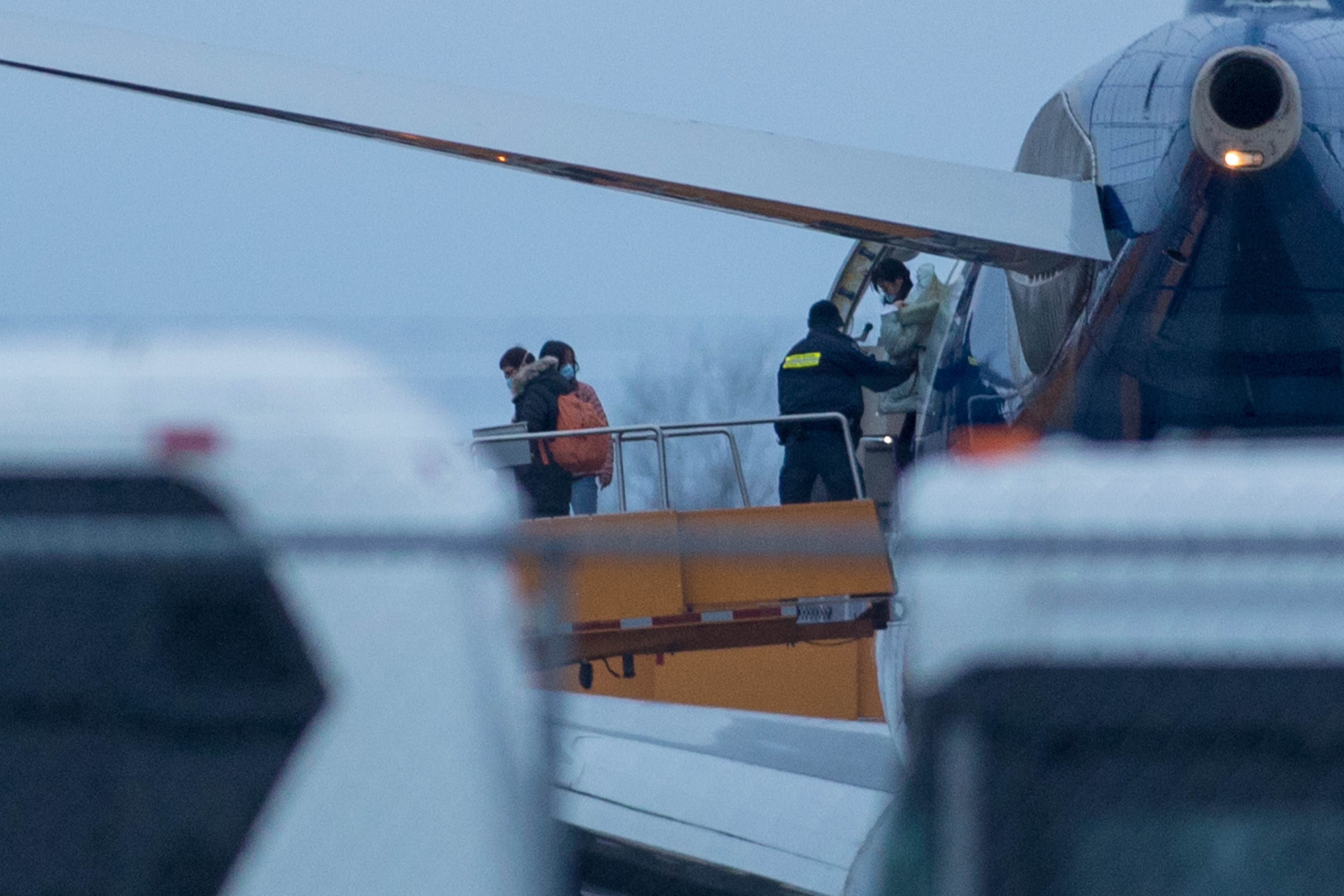 Passengers step off a plane carrying Canadians back from the Wuhan province in China, after it arrived at Canadian Forces Base Trenton in Trenton, Ont., on Feb. 11, 2020. (Lars Hagberg/CP)