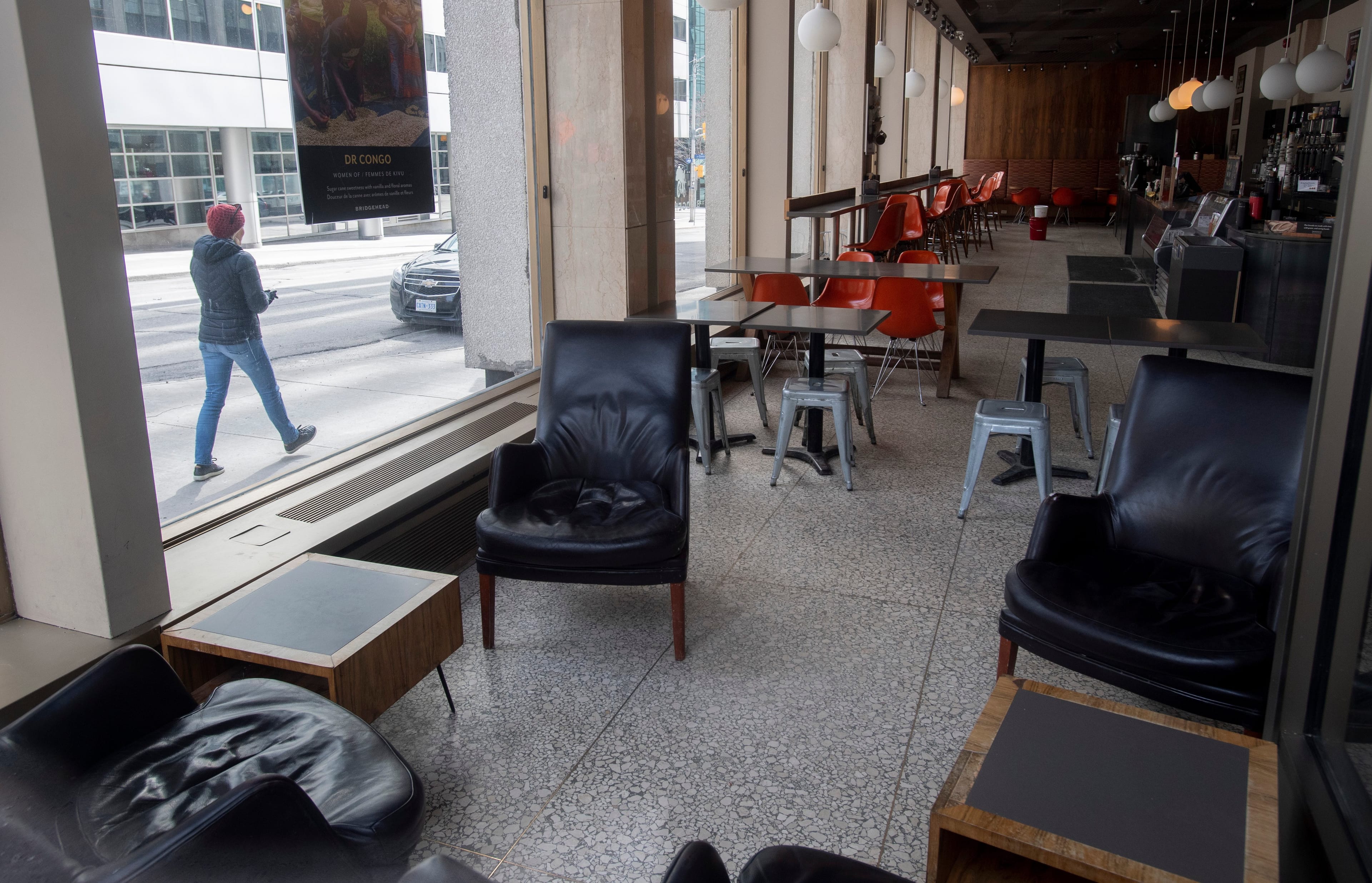 A woman walks past a coffee shop which closed because of the COVID-19 virus, Wednesday March 18, 2020 in Ottawa. (Adrian Wyld/CP)