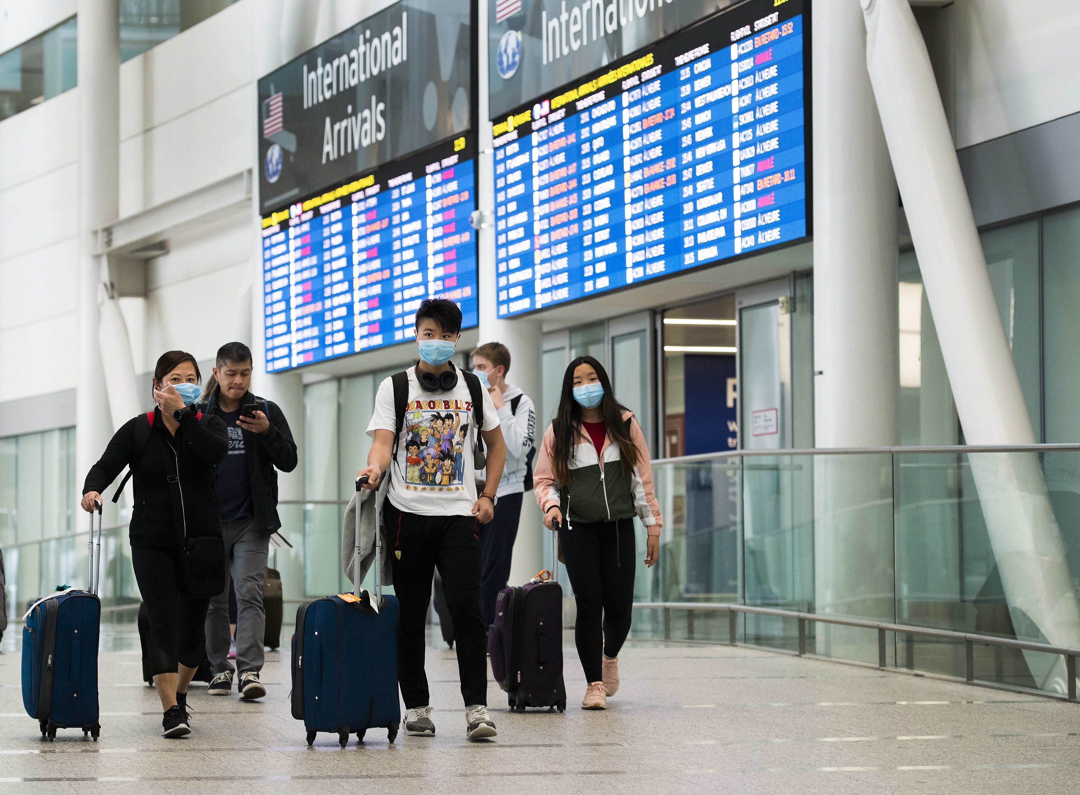 People arrive at Pearson International Airport in Toronto on Monday, March 16, 2020. As of midnight, all people returning to Canada will have to check in to a hotel or other designated site unless they have an acceptable self-quarantine plan.THE CANADIAN PRESS/Nathan Denette