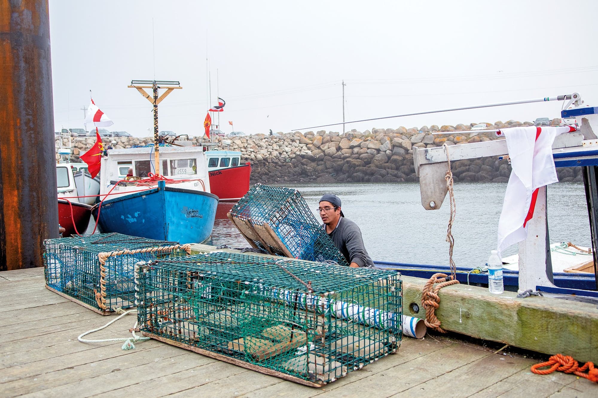 A fisherman prepares lobster traps at the Saulnierville wharf. (Photograph by Aaron McKenzie Fraser)
