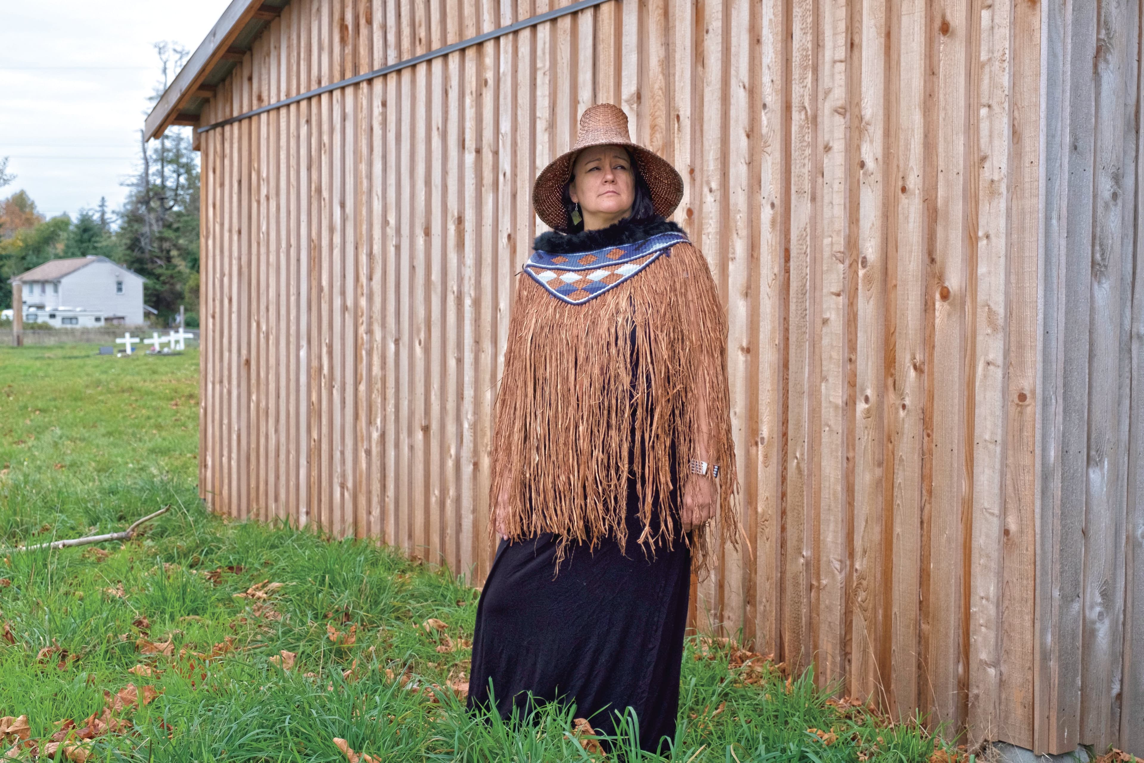Hegus (Chief) Nicole Rempel of the K'omoks First Nation stands in front of the mortuary house at the K'omoks cemetery. (Photograph by Jen Osborne)
