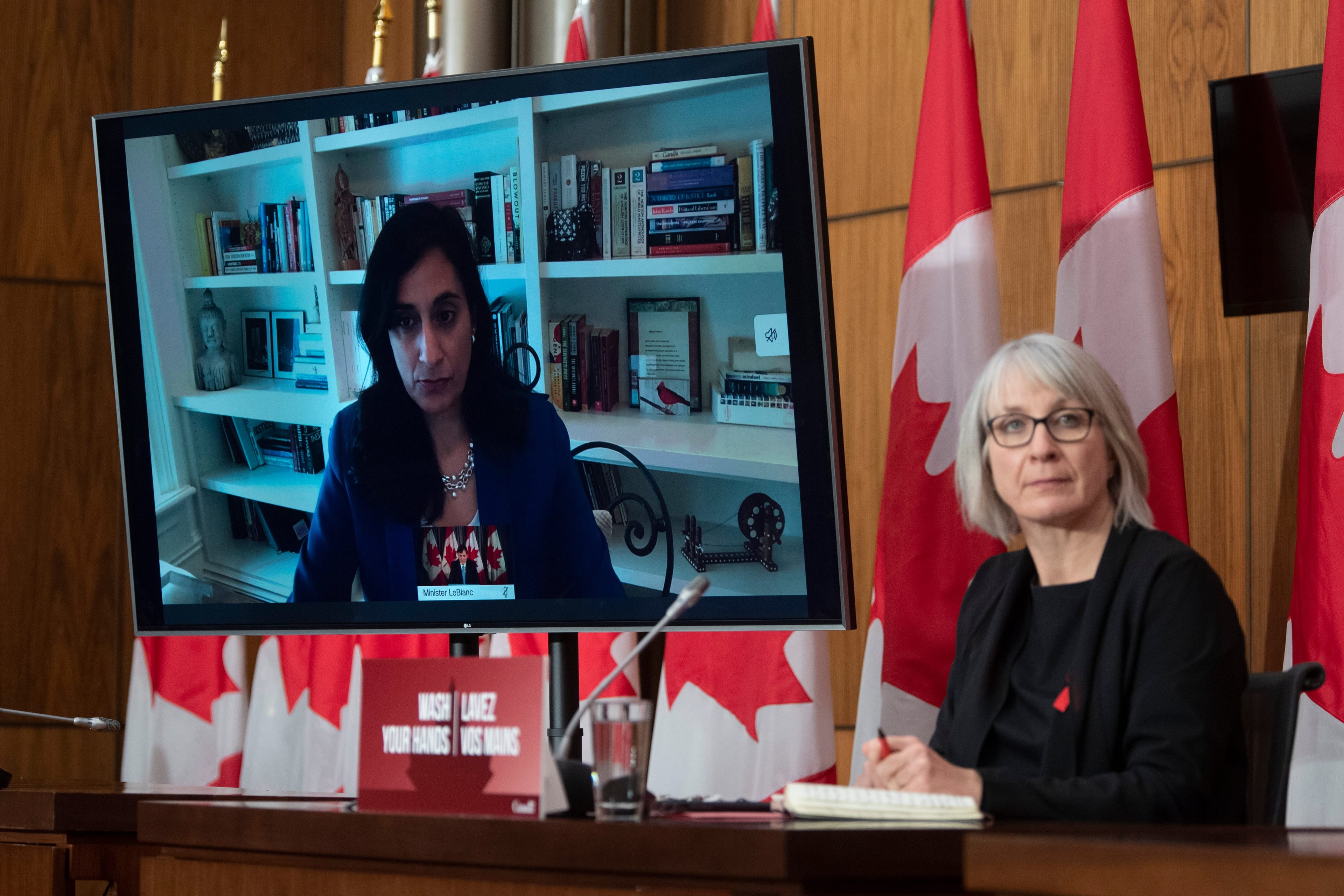 Public Services and Procurement Minister Anita Anand responds to a question via video conference as Minister of Health Patty Hajdu looks on during a news conference Tuesday Dec. 1, 2020 in Ottawa. (Adrian Wyld/CP)