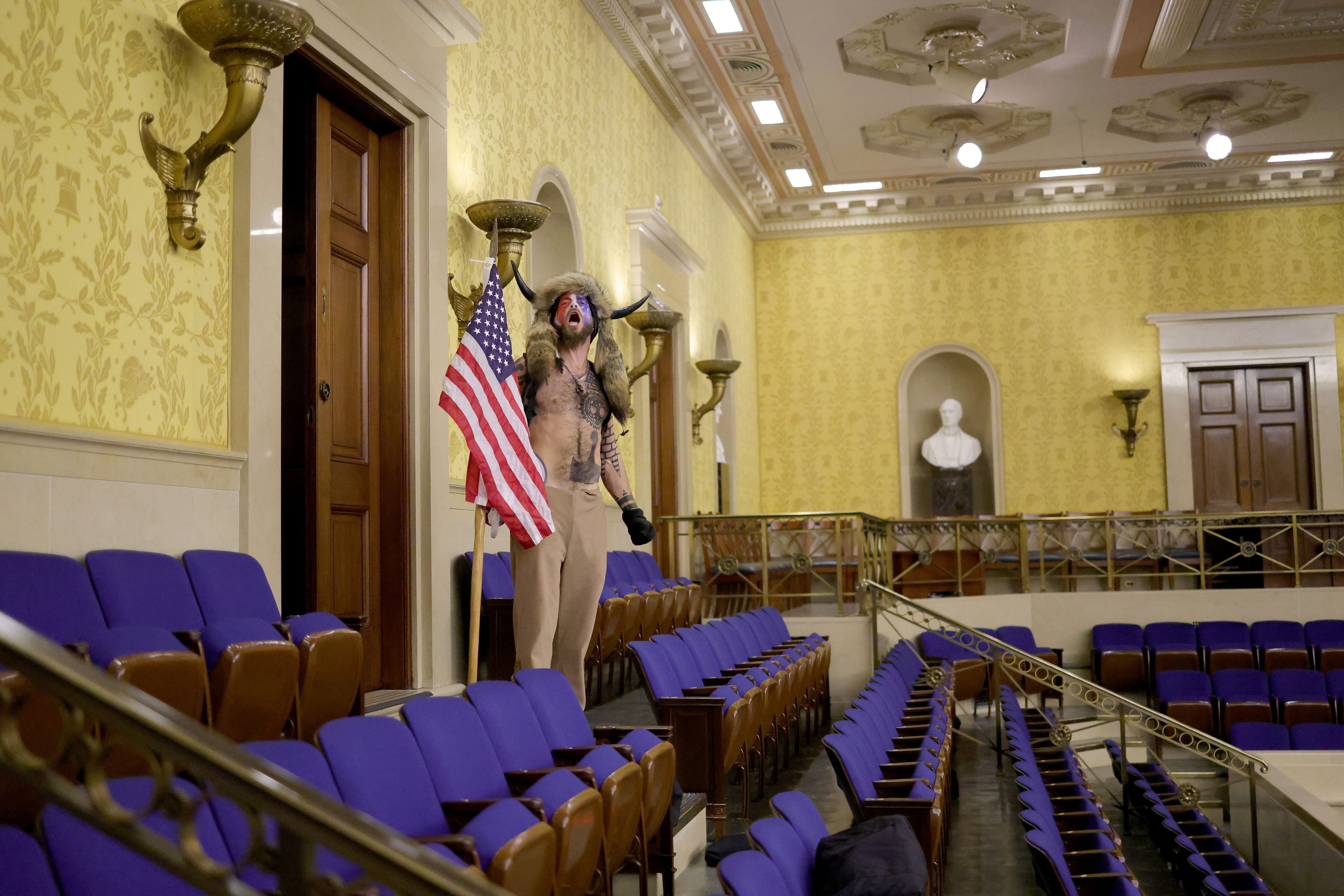 WASHINGTON, DC - JANUARY 06: A protester yells inside the Senate Chamber on January 06, 2021 in Washington, DC. Congress held a joint session today to ratify President-elect Joe Biden's 306-232 Electoral College win over President Donald Trump. Pro-Trump protesters entered the U.S. Capitol building during mass demonstrations in the nation's capital. (Win McNamee/Getty Images)