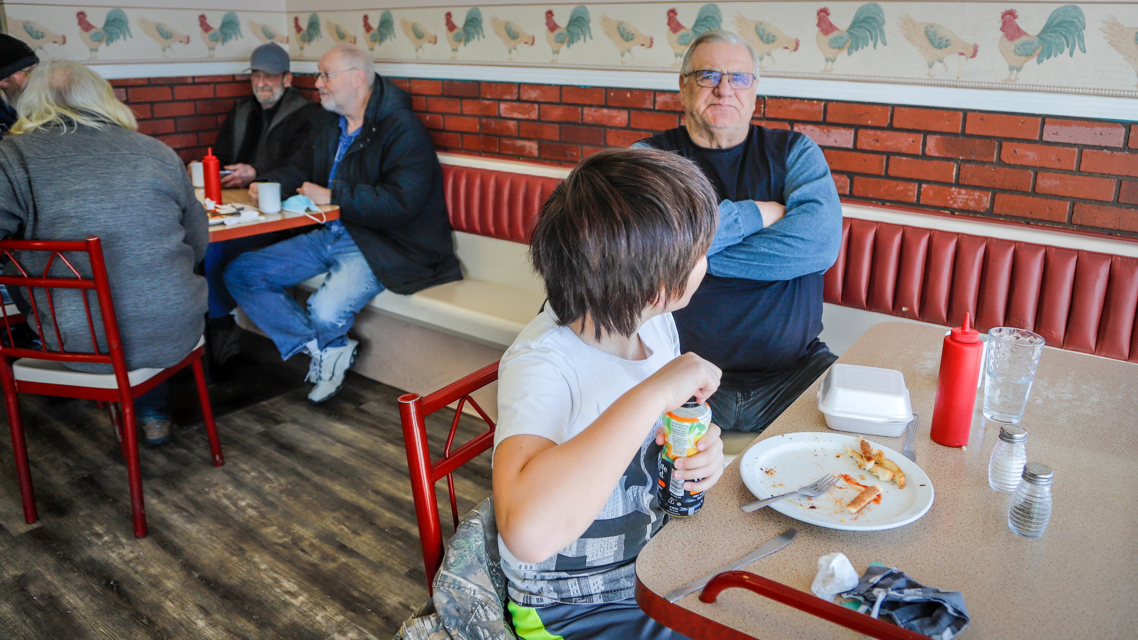 Wayne Smith and his grandson Matthew Lo, 10, enjoy dining in at Hunter's Country Kitchen, as Alberta begins Step 1 of a plan to ease restrictions, in Carstairs, Alta., Monday, Feb. 8, 2021. (Jeff McIntosh/CP)