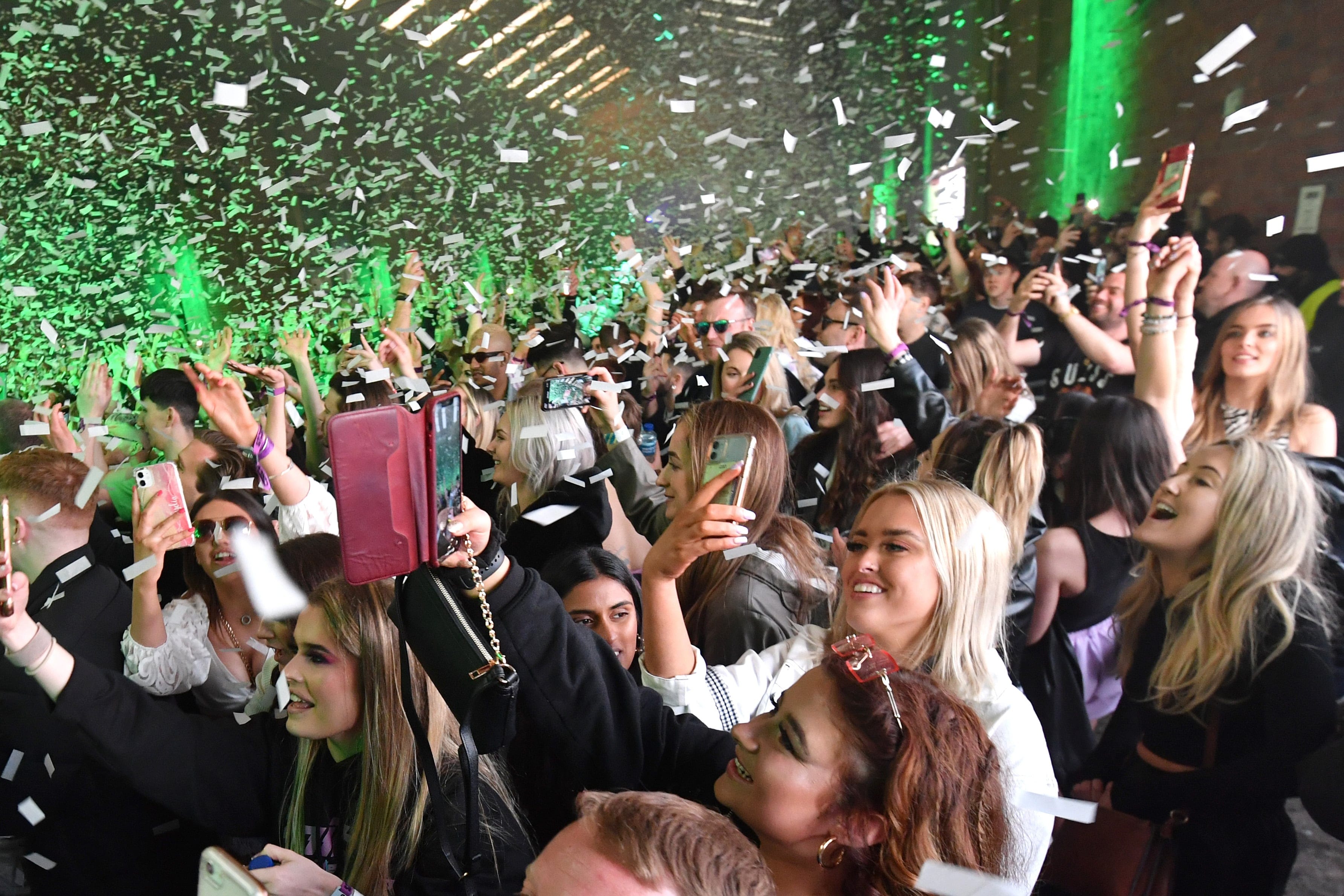 Confetti is fired into the crowd as Nightclub Circus hosts the first dance event, which will welcome 6,000 clubbers to the city's Bramley-Moore Dock warehouse on April 30, 2021 in Liverpool, England. The event is part of the national Events Research Programme which will provide data on how events could be permitted to safely reopen. (Anthony Devlin/Getty Images)