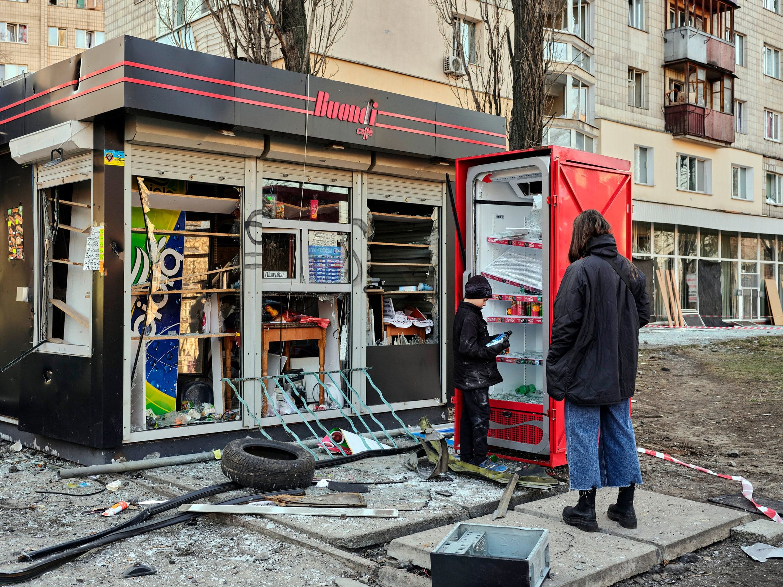 Kyiv, March 14. “The shockwave and shrapnel from the bombing of a nearby apartment complex destroyed this cafe. The media were looking at the apartment building, but I was watching this mother and son. Nobody else was taking photos of them. They were just casually inspecting the contents of the fridge. The civilian population has sort of normalized the constant bombardment. During the day, you see people shopping or enjoying a sunny day in a park while air-raid sirens are going off.” (Photograph by Philip Cheung)