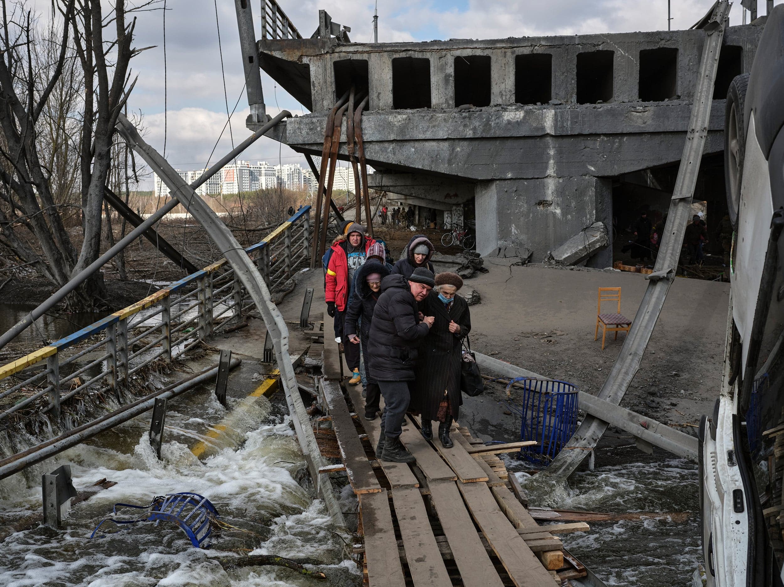 Irpin, March 10. Civilians evacuate Irpin by crossing the deliberately destroyed bridge over the Irpin river. (Photograph by Philip Cheung)