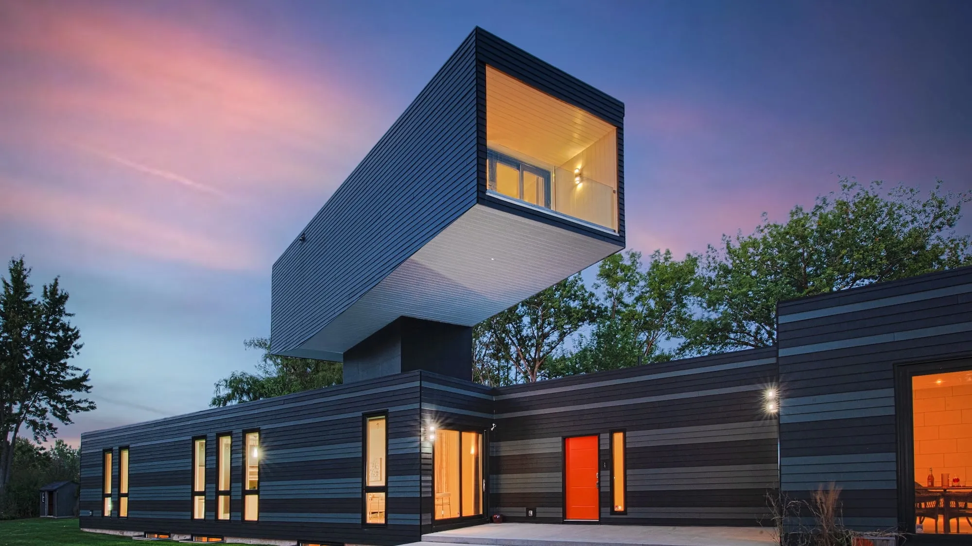 A large cubist home with one large cube over the main house