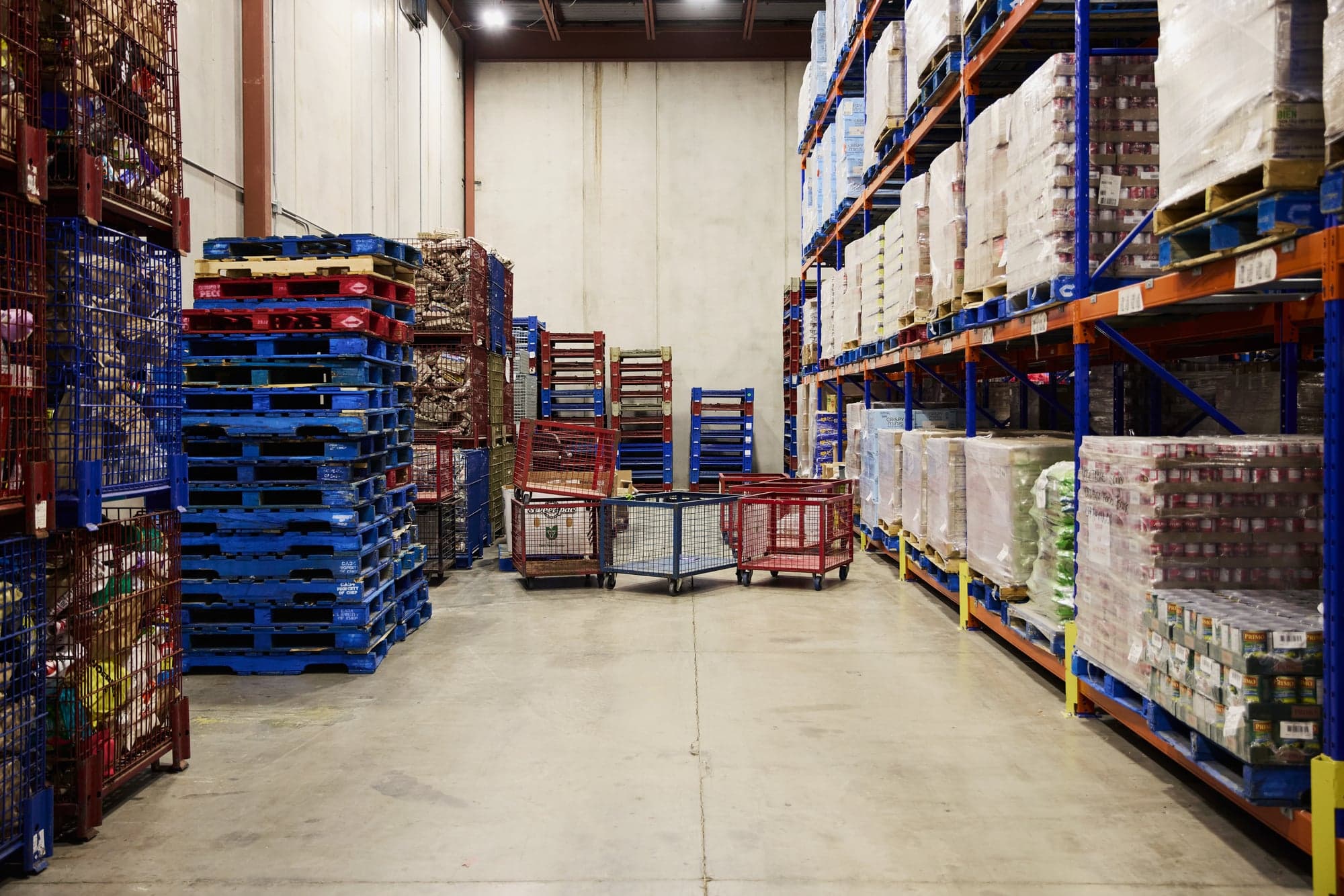 The floor of a food bank, with shelves piled high