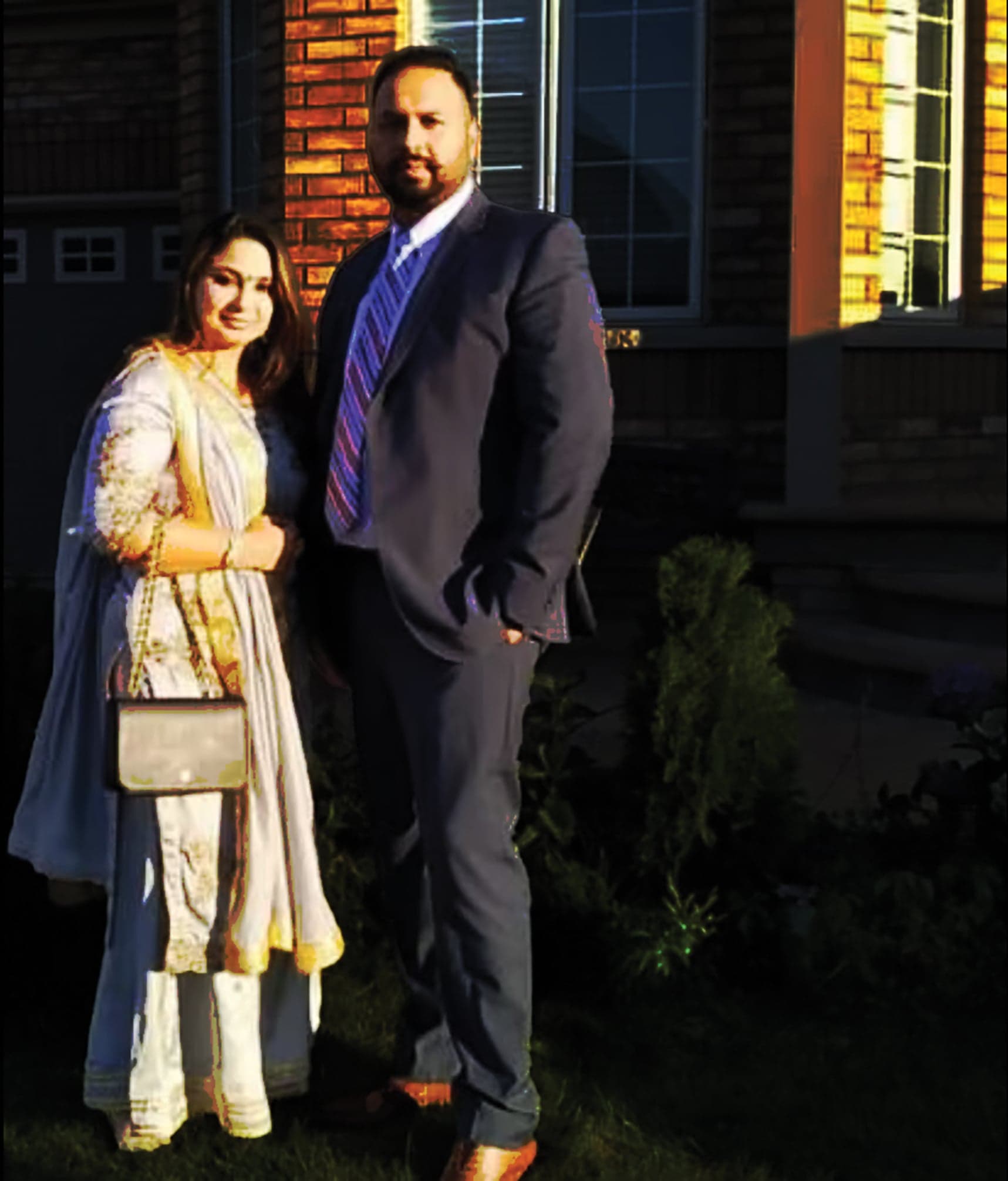 A woman in light-coloured clothing standing beside a man in a suit