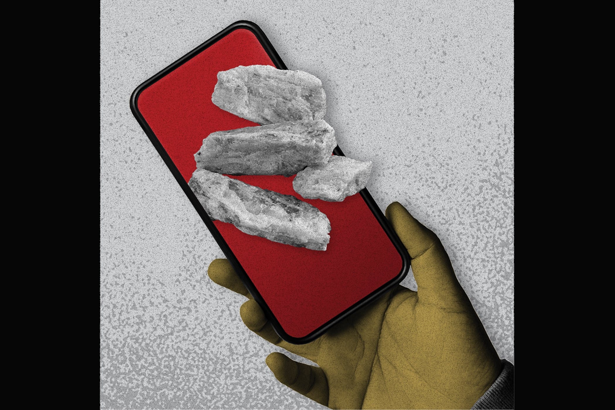 Lithium ore in front of a cell phone, held by a gloved hand