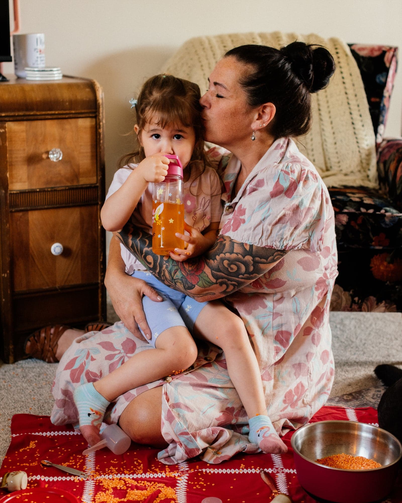 A woman in pajamas holding a toddler