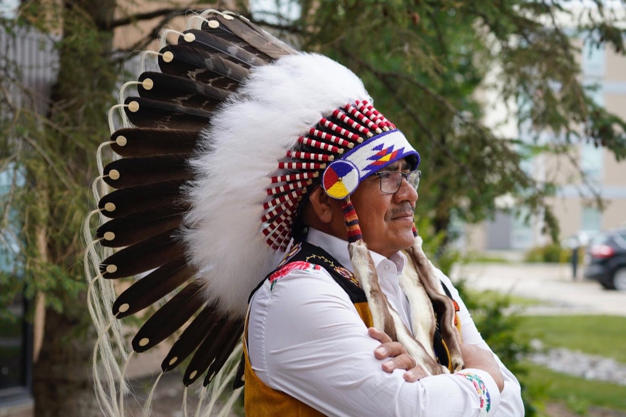 Sheldon Sunshine, the chief of Sturgeon Lake Cree Nation, in an elaborate feather headdress