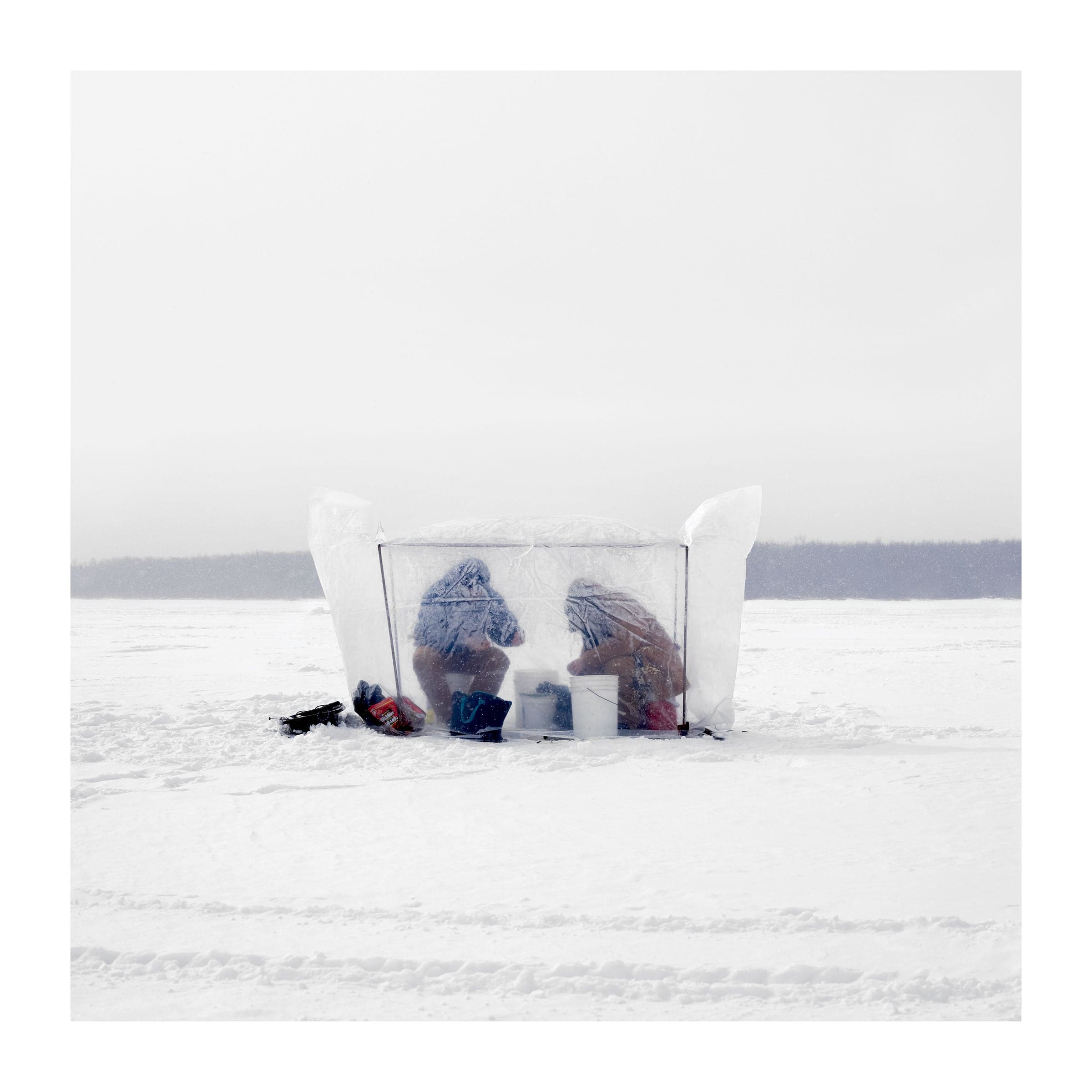 A Transparent ice hut, containing two people huddled inside