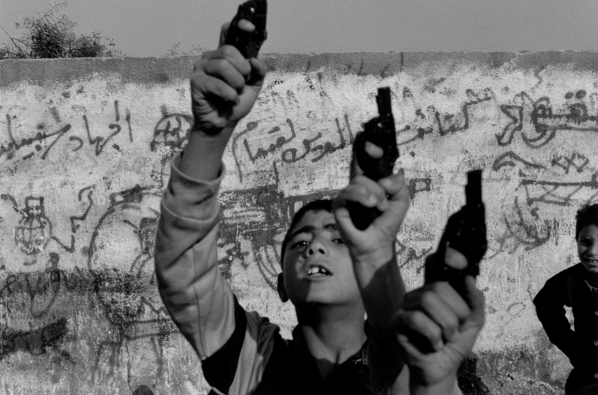 Children holding toy guns in the air
