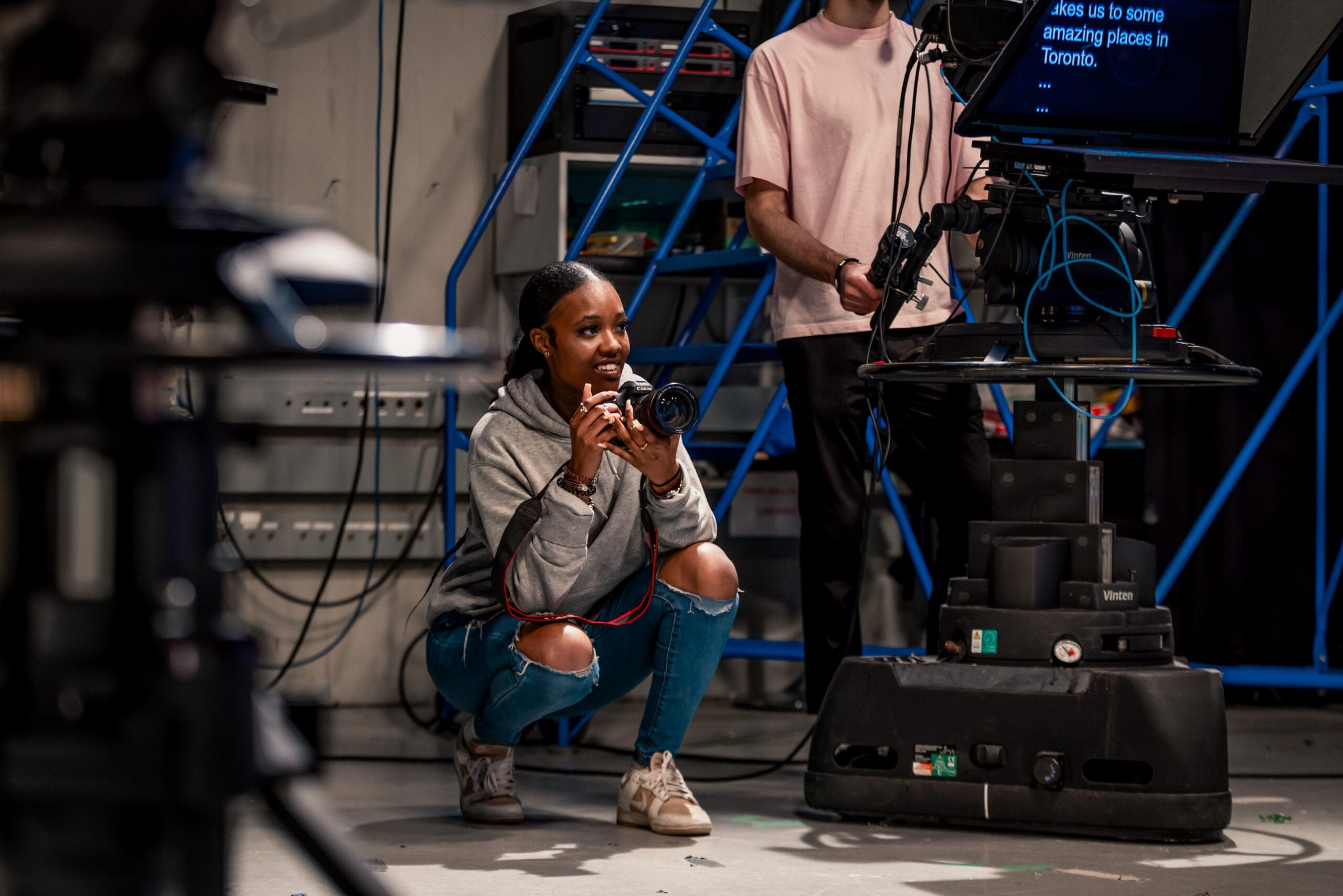 A student holding a camera in a studio