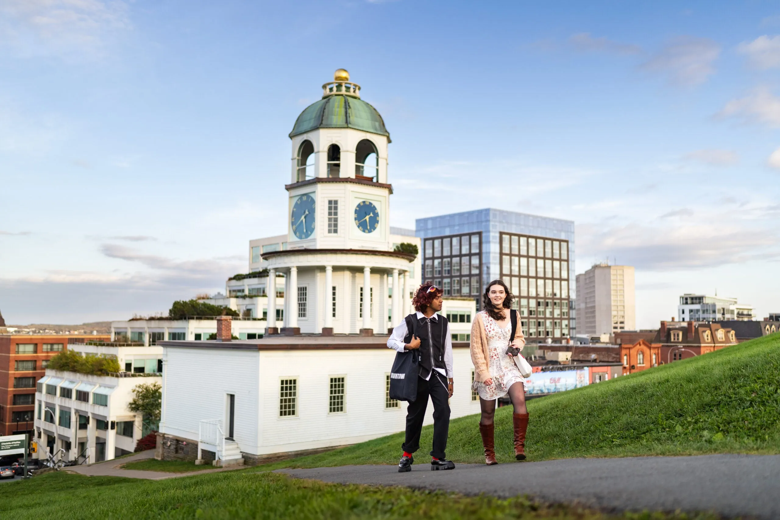 A white university building with two students outside it