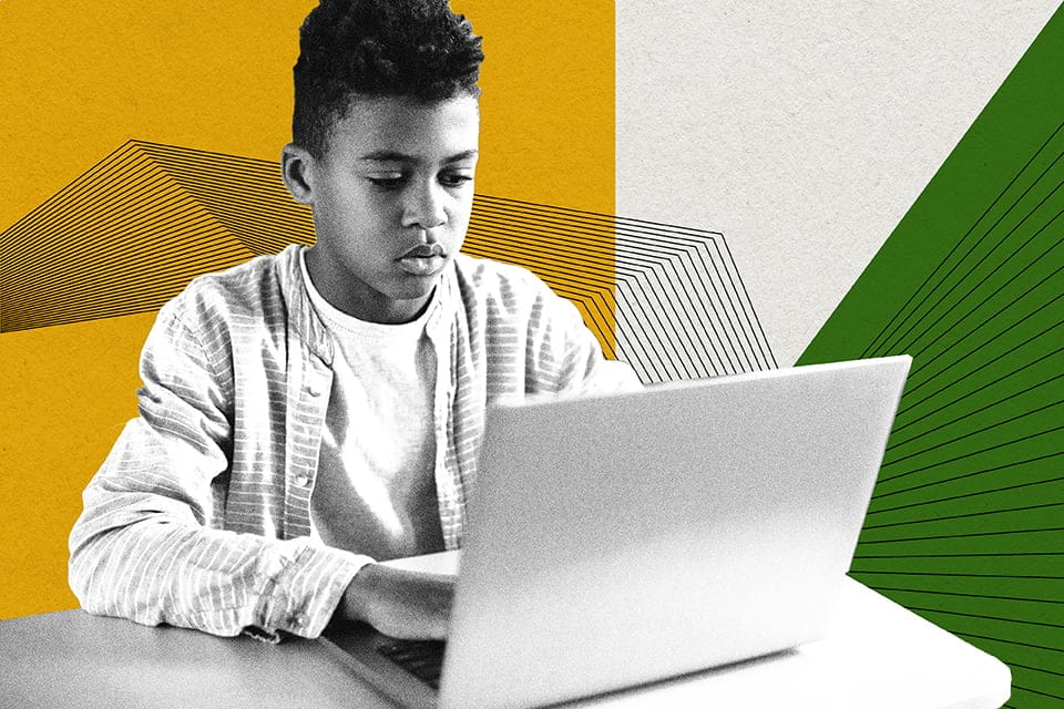 A young boy doing some work on a laptop