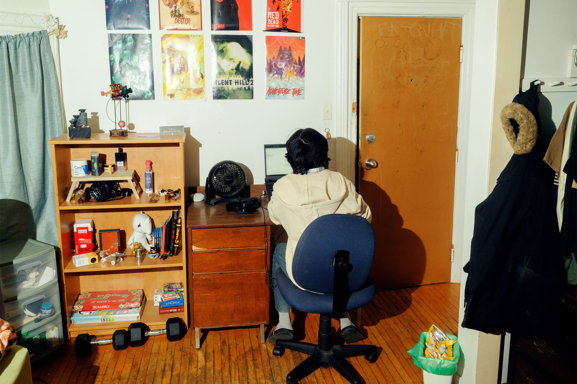 a student sitting at his desk in his bedroom