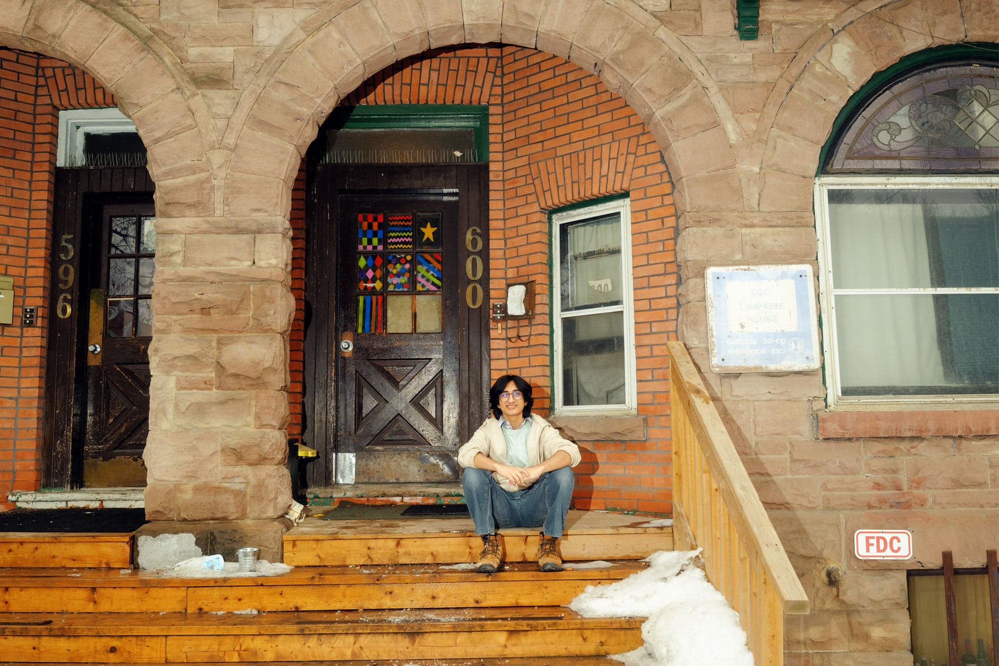 a student sitting on the front steps of his student house