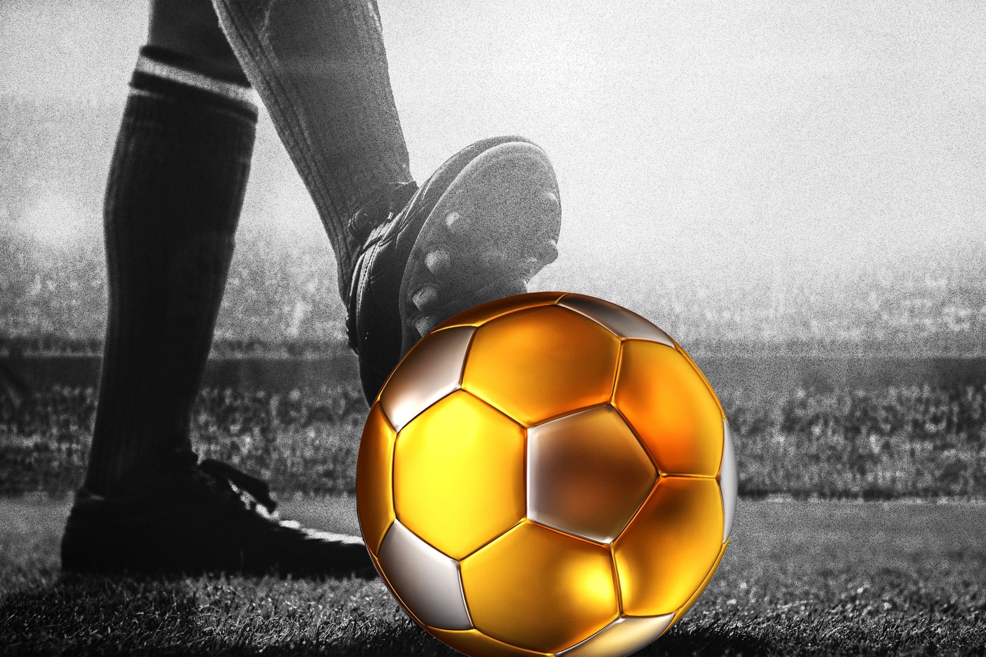 A black and white picture of a leg resting their cleat on a gold soccer ball.