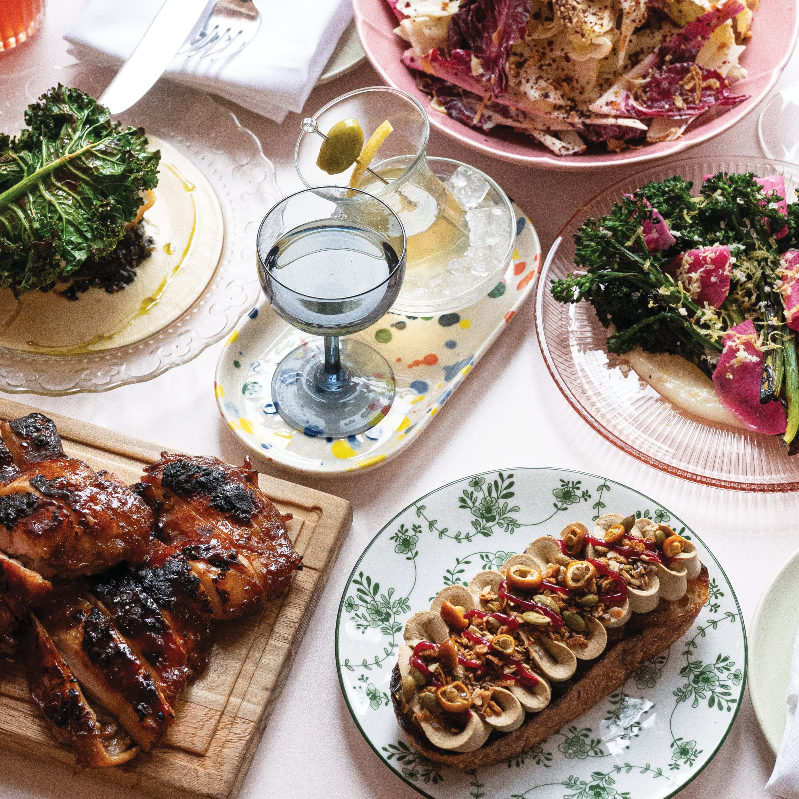 Variety of meals on the plates, placed on the baby pink-coloured table