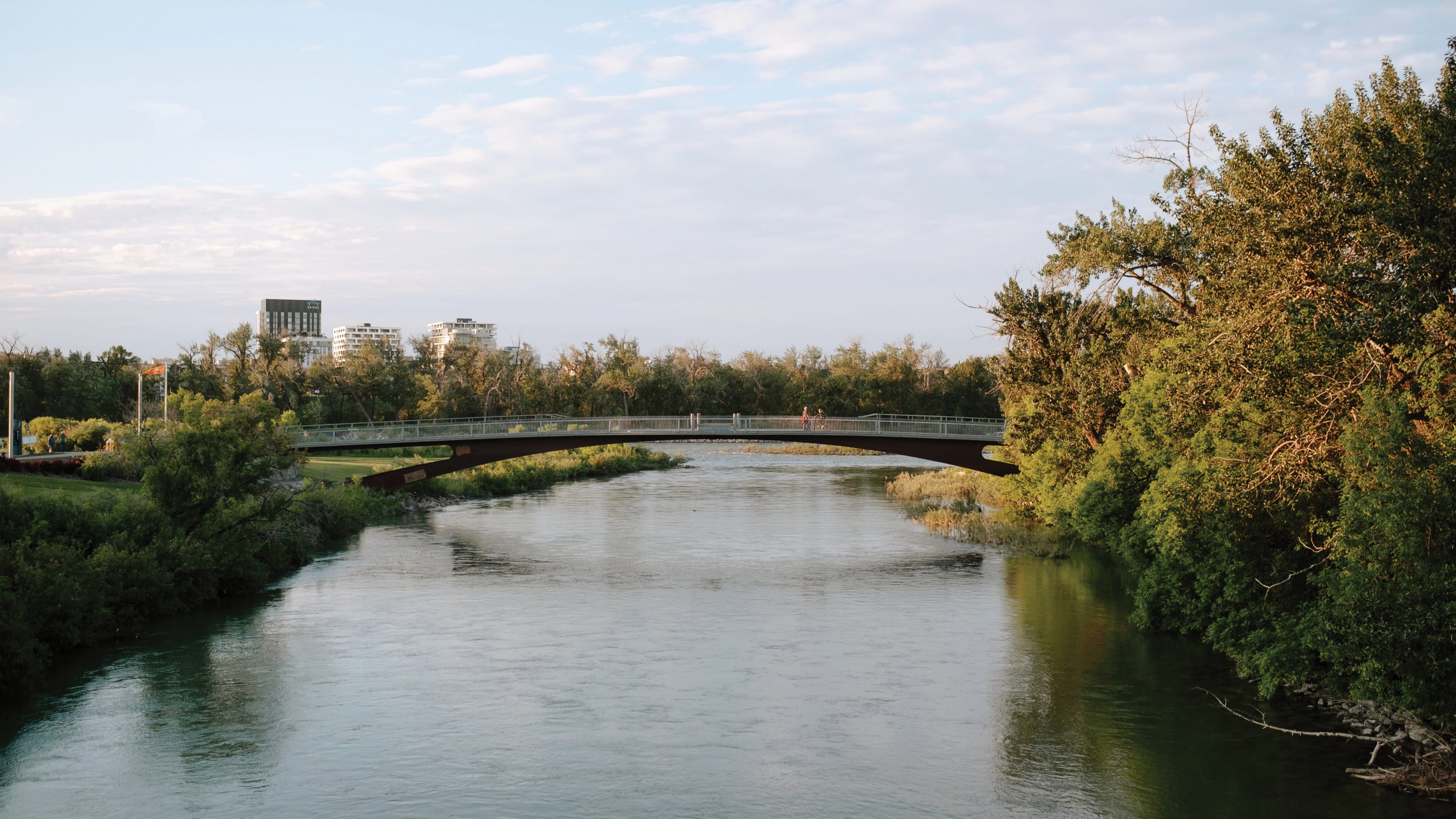 River and a bridge under the blue sky. The shadow of the bridge reflecting on the river