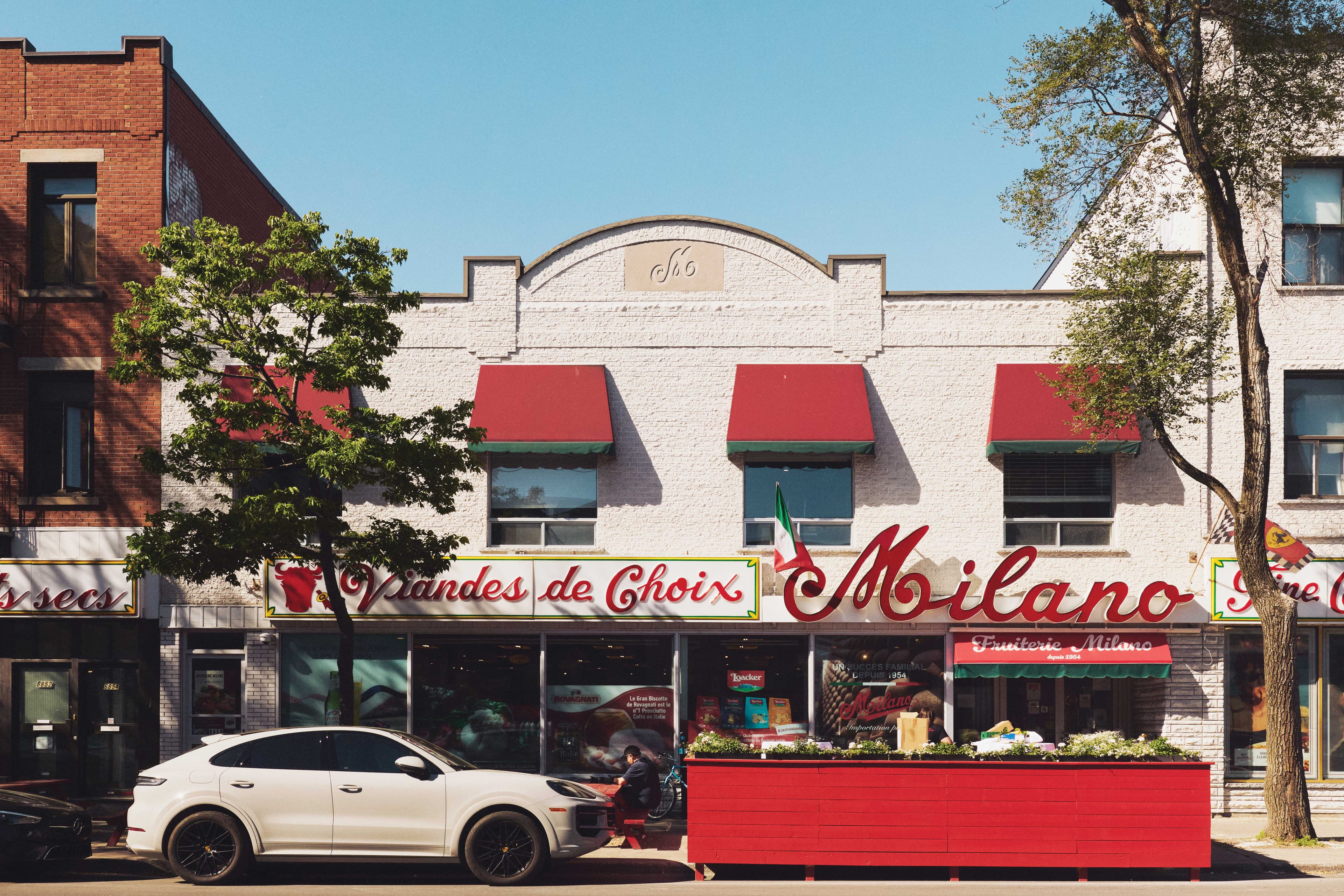 Storefront of a grocery store that has a Italian flag and words that says "Viandes de Choix" and "Milano"