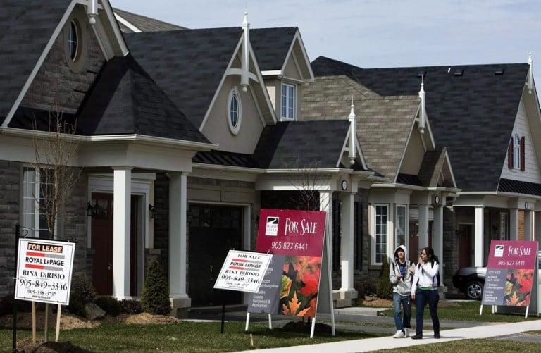 <p>FILE&#8211;People walk past new homes that are for sale in Oakville, Ont., on Tuesday, April 14, 2009. The costs associated with home ownership in Canada will continue to rise this year and in 2011 as higher mortgage rates set in before there is any substantial drop in prices, two of Canada&#8217;s major banks predicted Tuesday. THE CANADIAN PRESS/Nathan Denette</p>
