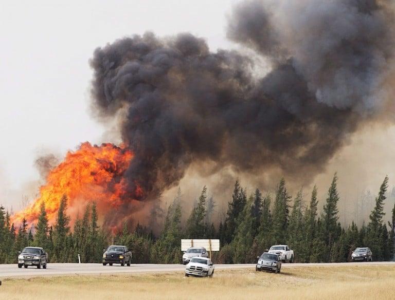 <p>A convoy of evacuees from Fort McMurray, Alberta drive past wildfires that are still burning out of control as they leave the city Saturday, May 7, 2016. (Ryan Remiorz/CP)</p>
