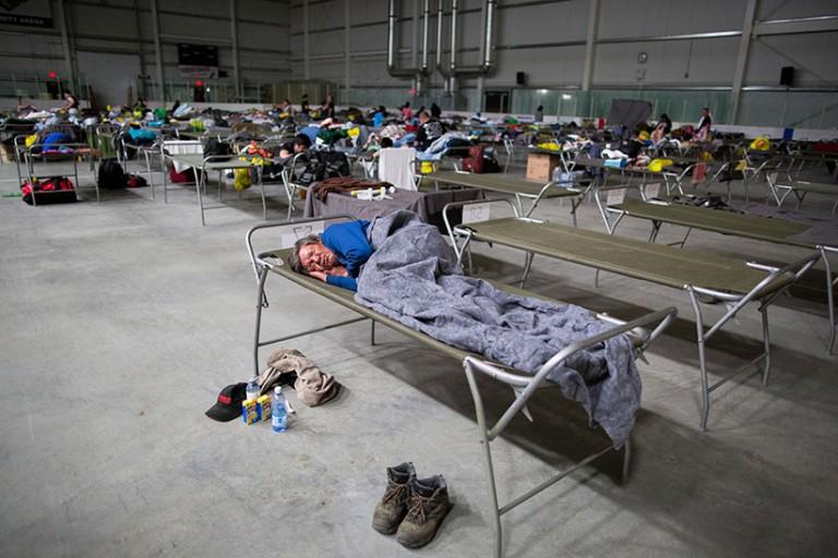 <p>Residents of Fort McMurray get some rest in on cots at the Bold Centre in Lac La Biche, AB after being evacuated from fires that have taken over northern Alberta on Wednesday, May 04, 2016. (Photograph by Chris Bolin)</p>
