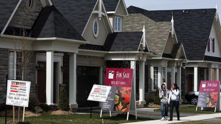 <p>People walk past new homes that are for sale in Oakville, Ont. THE CANADIAN PRESS/Nathan Denette</p>
